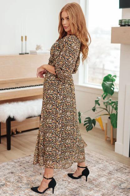 Black/orange floral maxi dress with square neckline and ruffle details, side view.