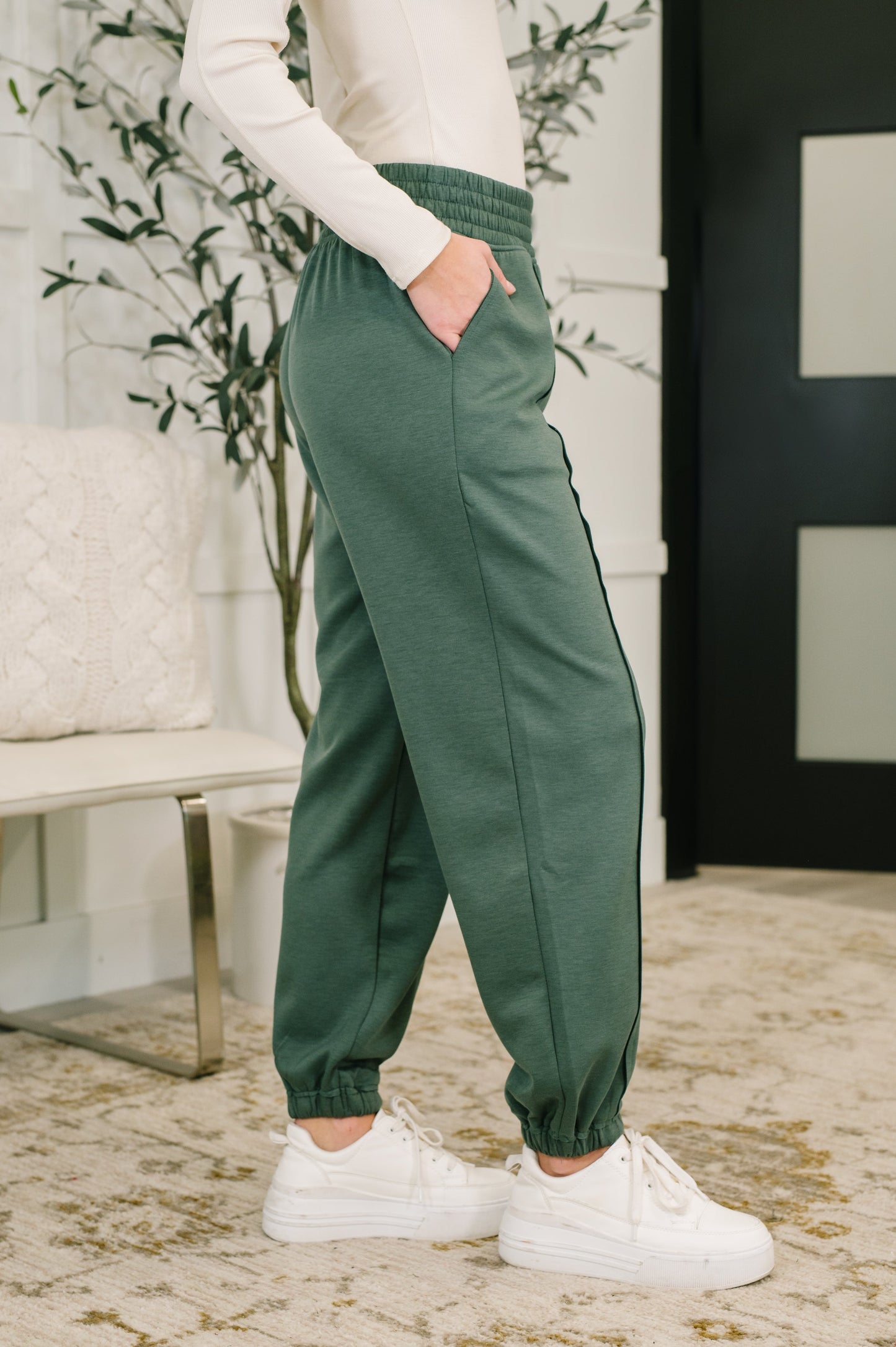 Side angle of Evani Jogger Bottoms highlighting exposed seam details and stretch.