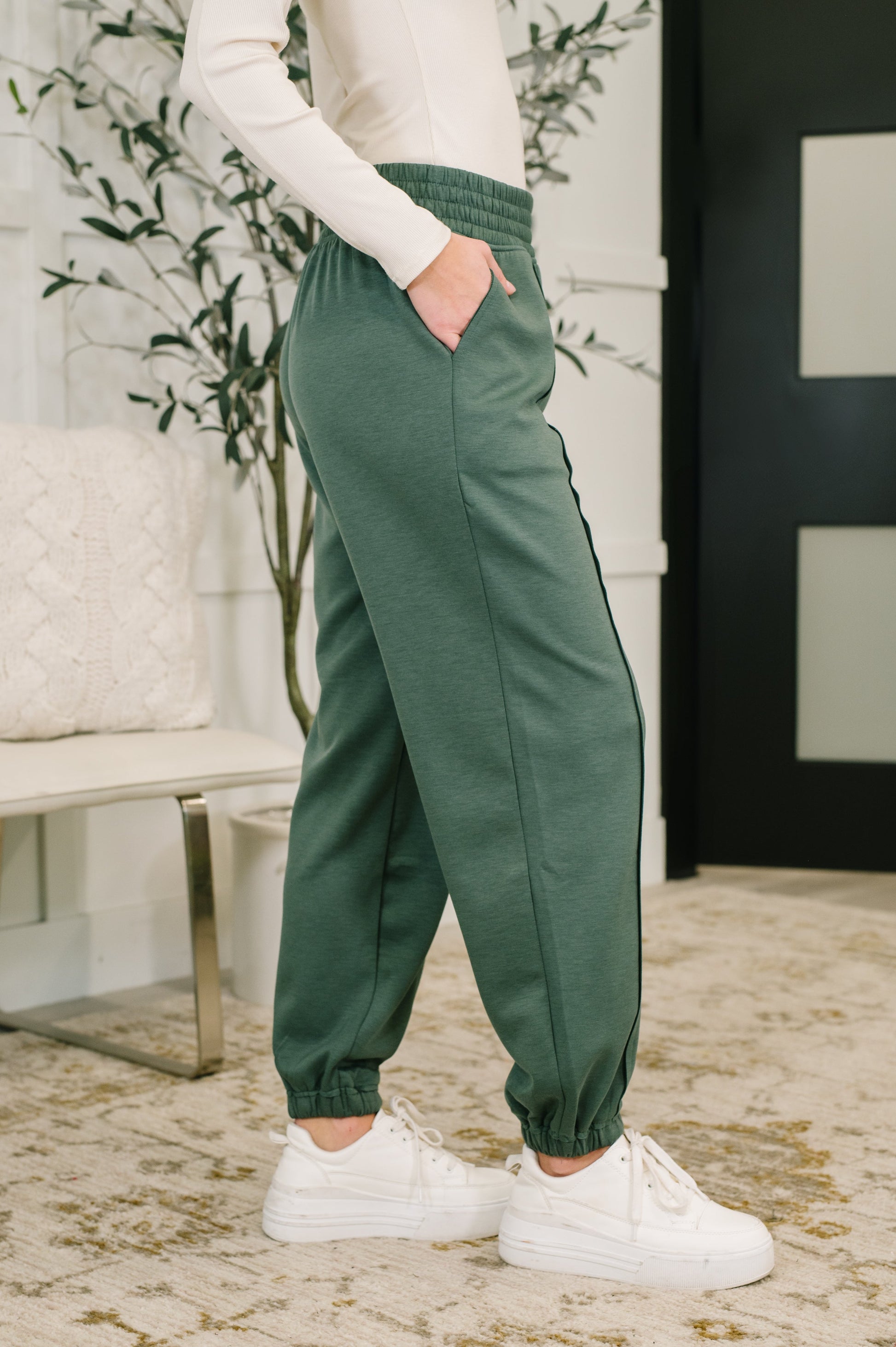 Side angle of Evani Jogger Bottoms highlighting exposed seam details and stretch.