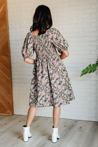 Back view of Skyla Floral Dress highlighting smocked fit and flowy floral skirt.