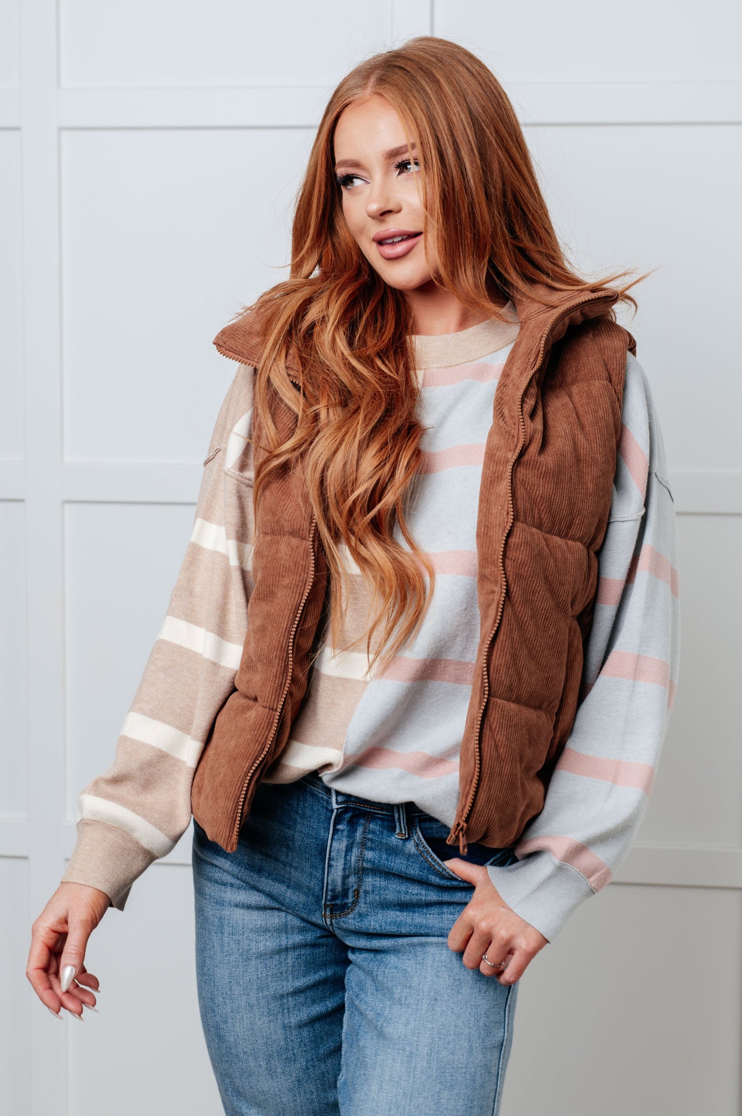 A women's sweater in beige and light gray stripes, made of midweight sweater knit fabric. It features a banded micro-ribbed neckline, long drop-shoulder sleeves with banded micro-ribbed cuffs, exposed seam details, and side slits.