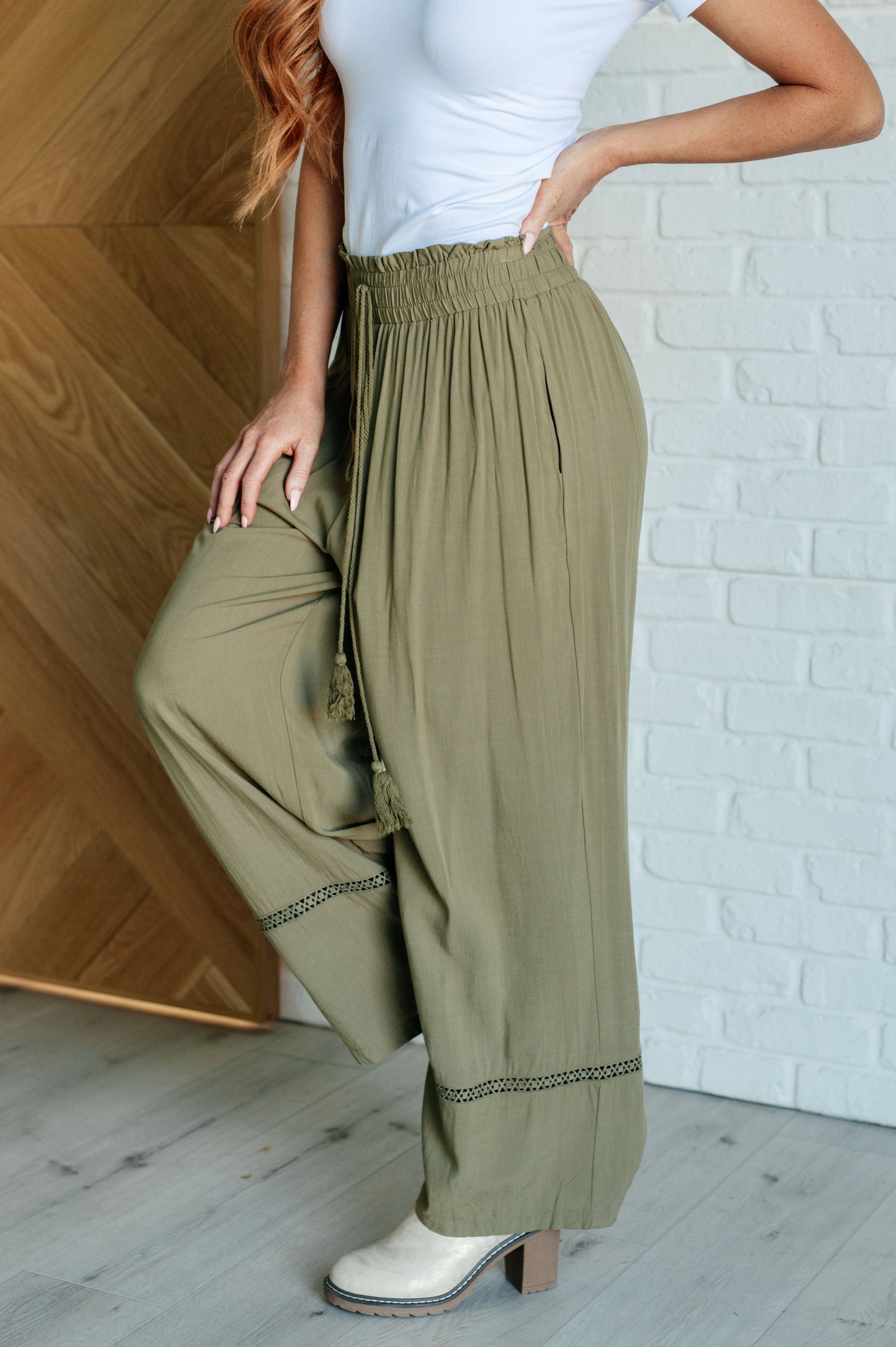 Olive wide-leg pants with a ruffled elastic waistband, geometric embroidery, and tasseled drawstring