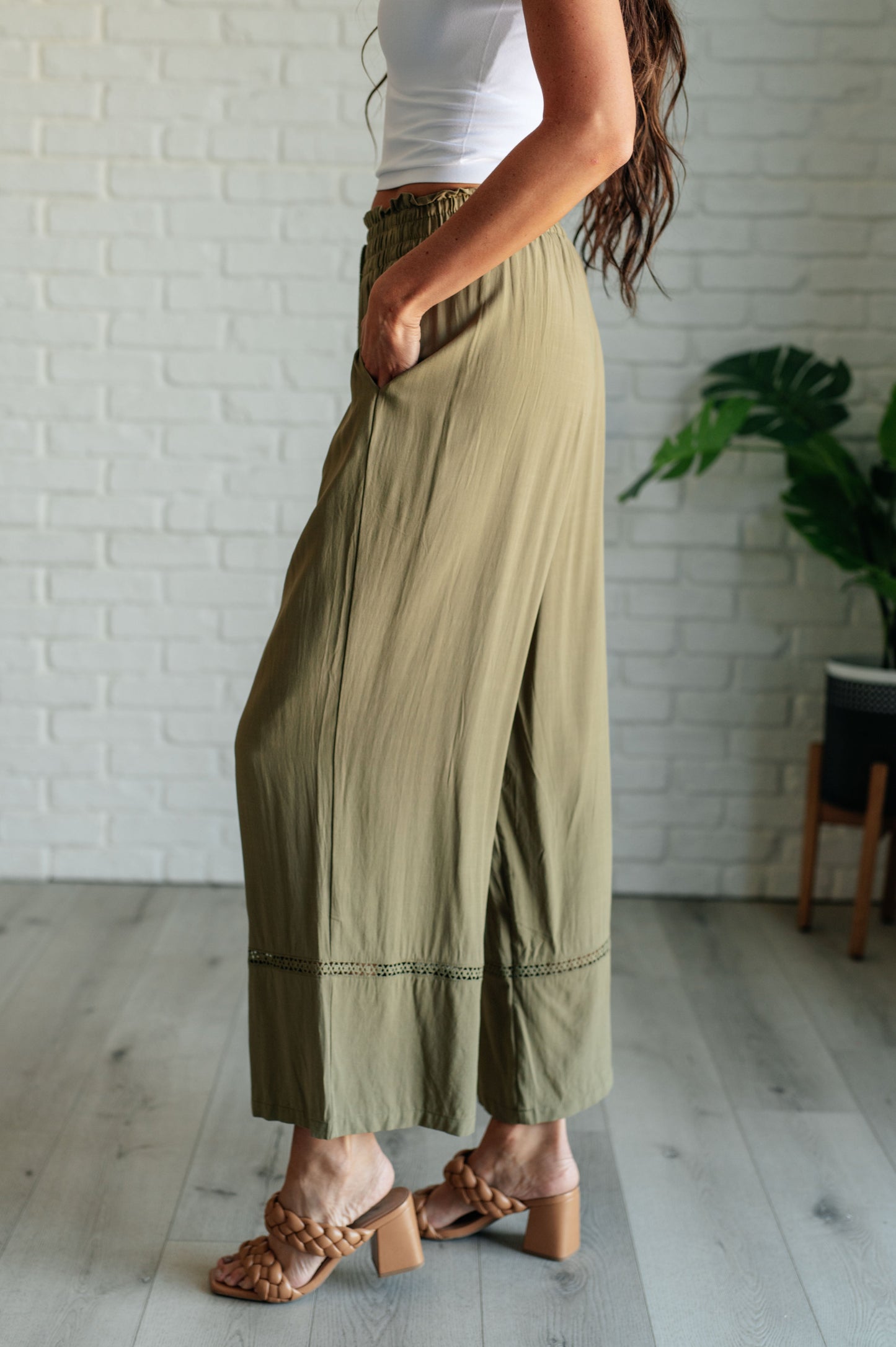 Olive wide-leg pants with a ruffled elastic waistband, geometric embroidery, and tasseled drawstring