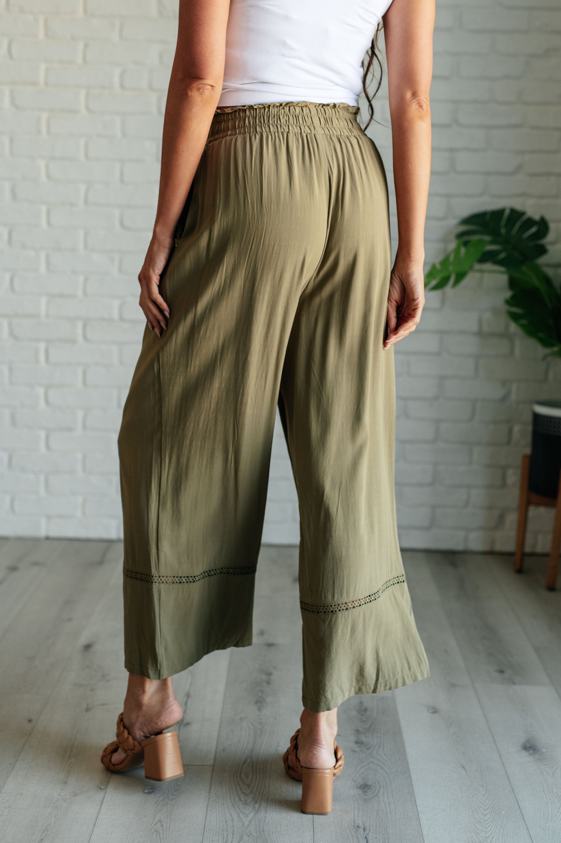 Olive wide-leg pants with a ruffled elastic waistband, geometric embroidery, and tasseled drawstring