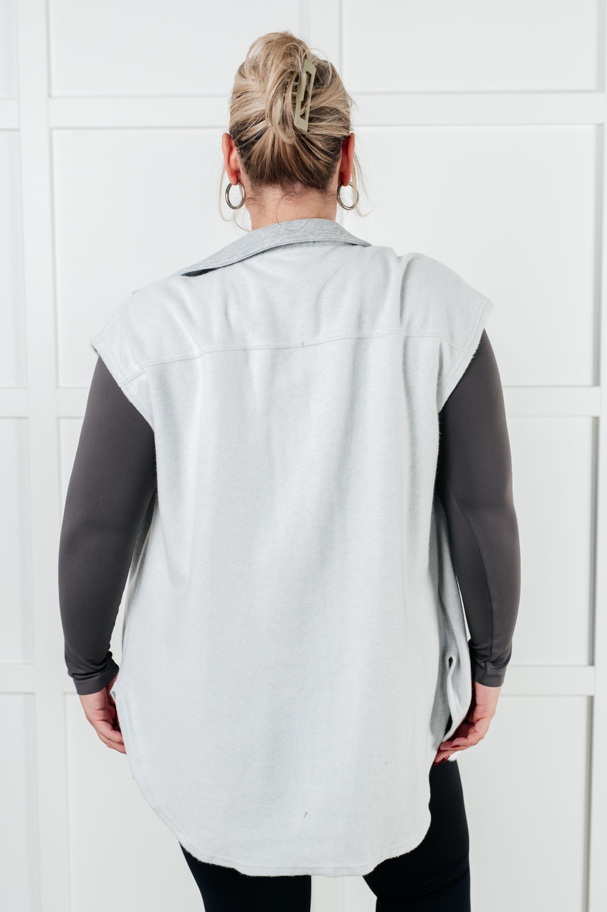 Women's Sleeveless Shacket in white with heather grey accents, featuring a collared neckline, full front button closure, chest patch pockets, and a scooped hemline. Made from soft poly cotton fleece.