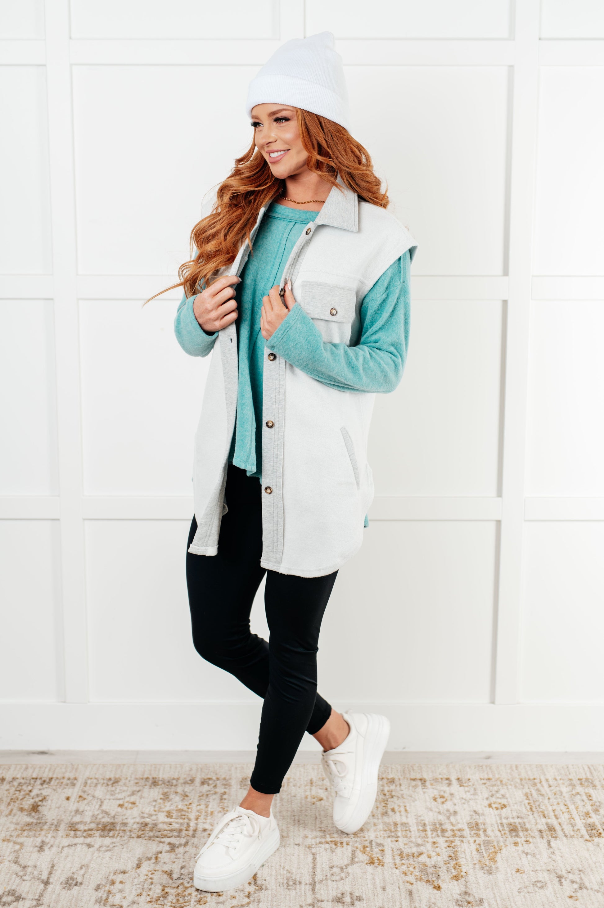 Women's Sleeveless Shacket in white with heather grey accents, featuring a collared neckline, full front button closure, chest patch pockets, and a scooped hemline. Made from soft poly cotton fleece.