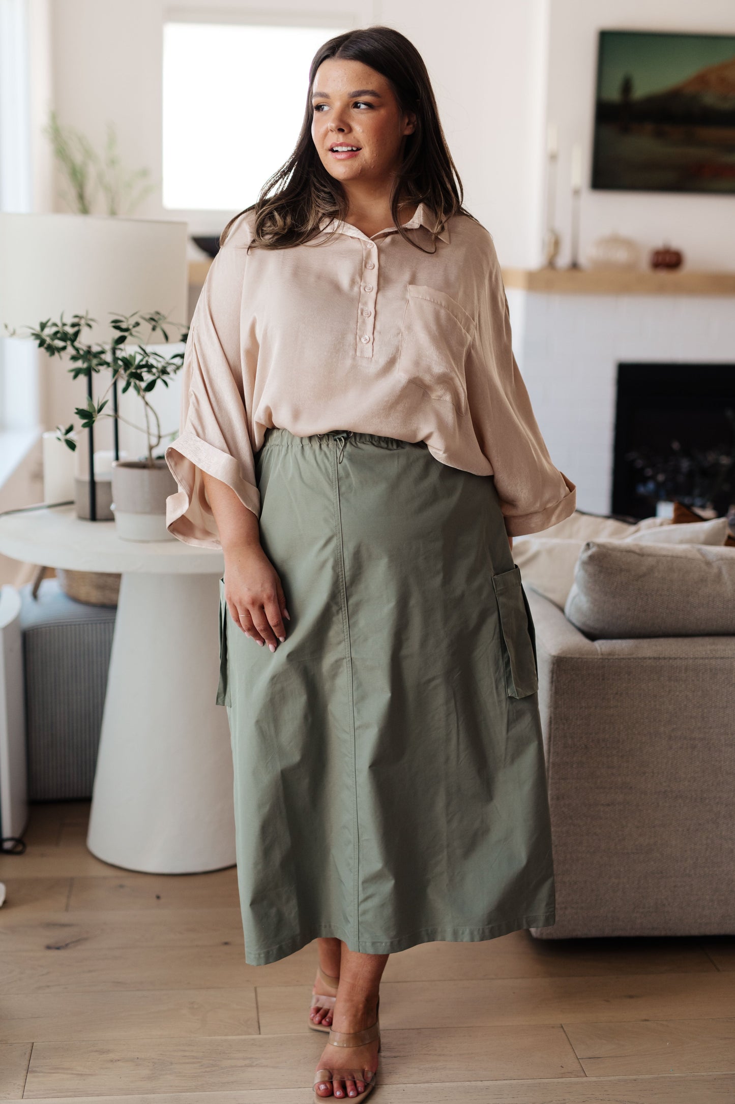 Champagne-colored poly satin top with a collared neckline, quarter-length button placket, oversized dolman sleeves with rolled cuffs, and a boxy, oversized fit.