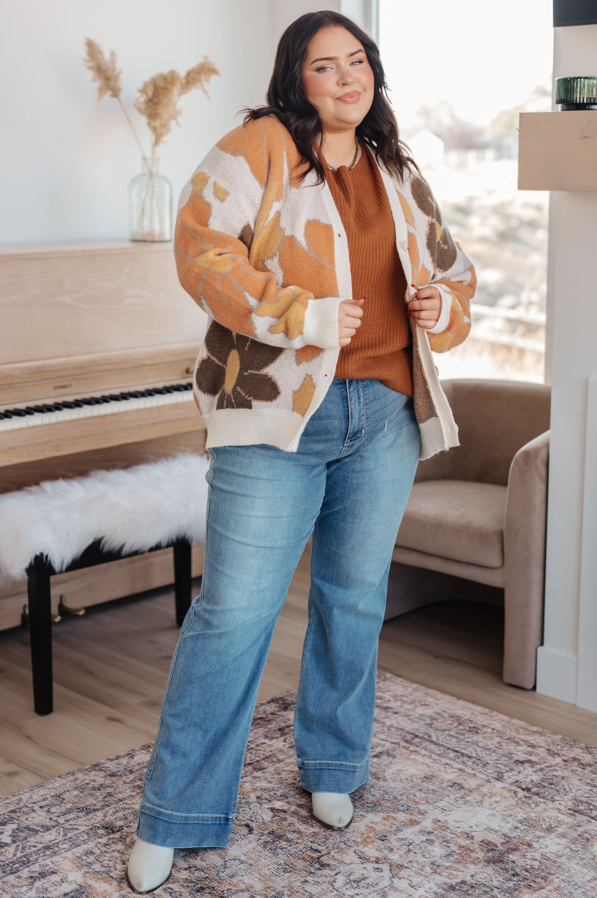  Women's floral sweater in brown, cream, orange, and yellow, featuring a V-neckline, long drop-shoulder sleeves, ribbed hem and cuffs, and a relaxed fit. Made from sweater knit fabric.