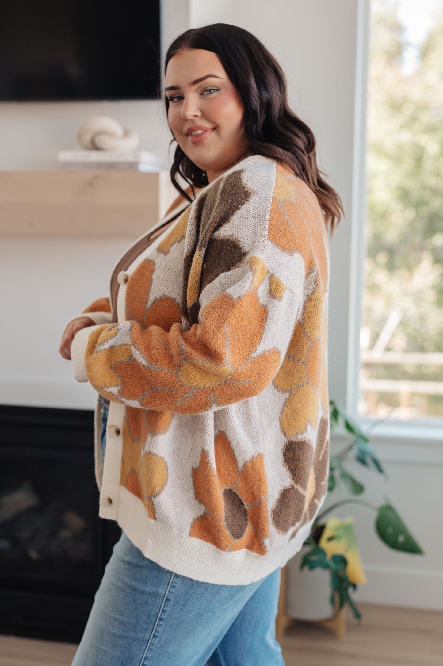  Women's floral sweater in brown, cream, orange, and yellow, featuring a V-neckline, long drop-shoulder sleeves, ribbed hem and cuffs, and a relaxed fit. Made from sweater knit fabric.