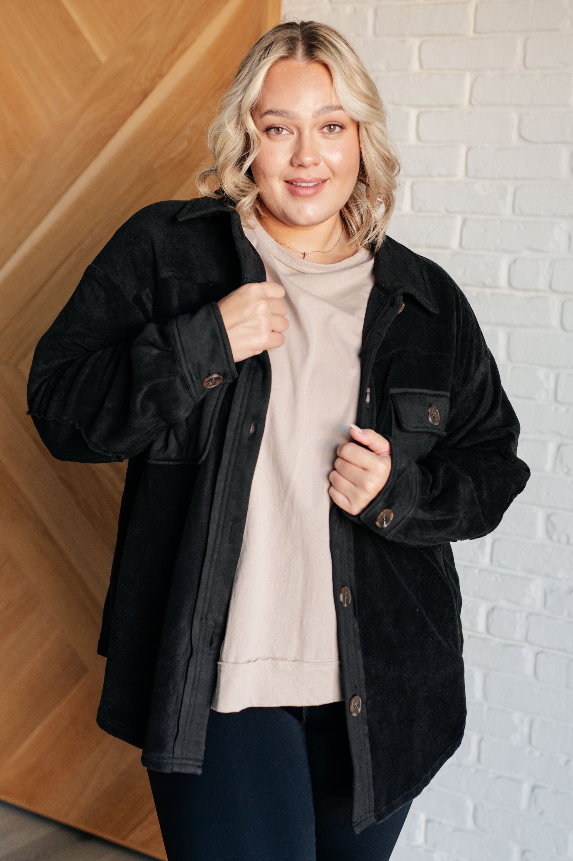 Black fleece jacket with a collared neckline, contrast panels, elbow patches, functional button closures, and banded sleeve cuffs. Features chest patch and side welt pockets.