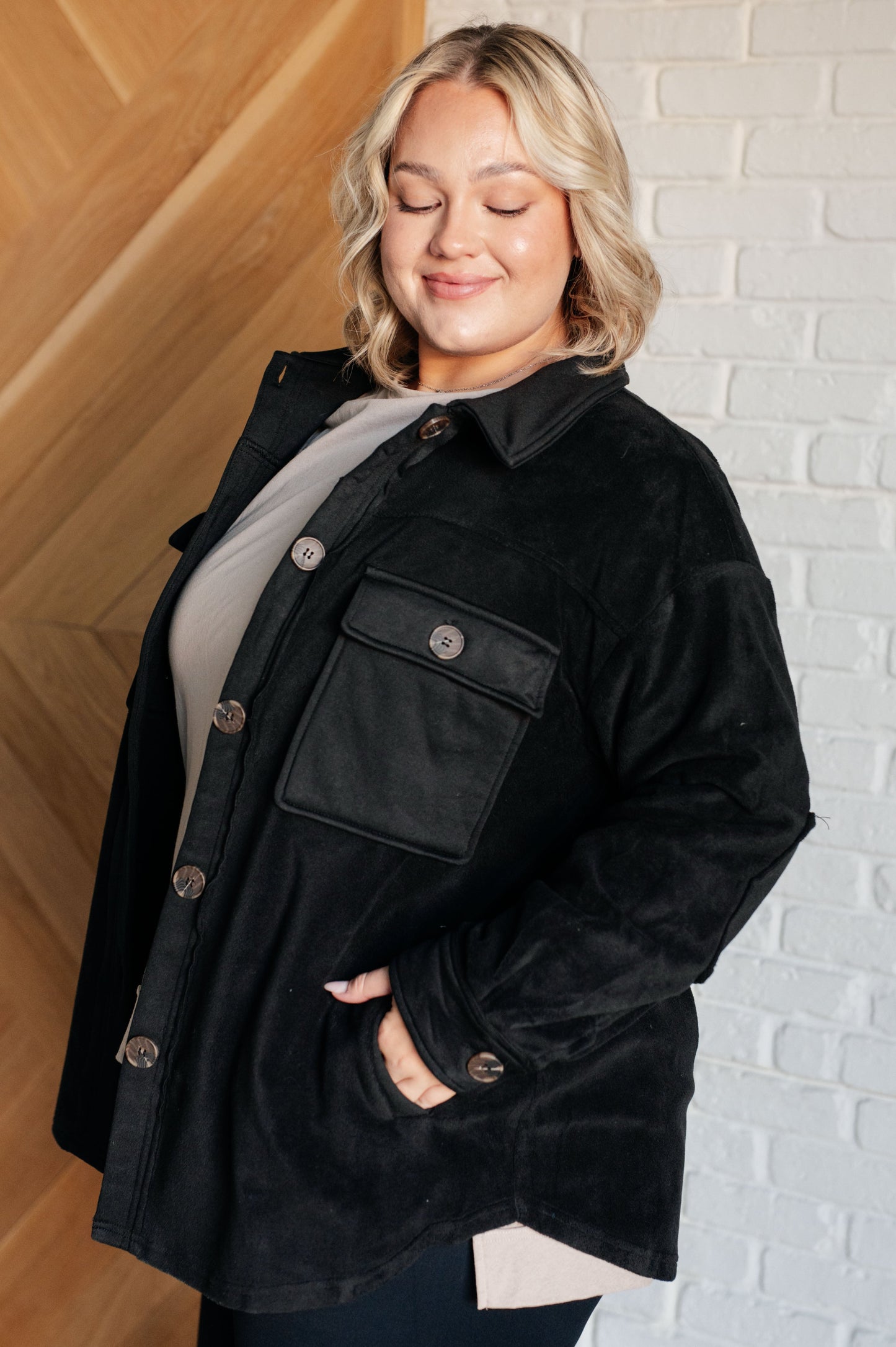 Black fleece jacket with a collared neckline, contrast panels, elbow patches, functional button closures, and banded sleeve cuffs. Features chest patch and side welt pockets.