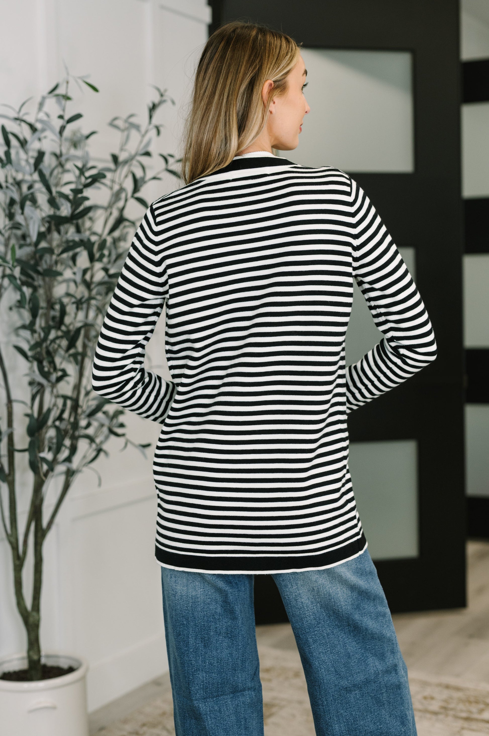 Back view of Finn Striped Cardigan showing black and white stripe pattern and hemline.