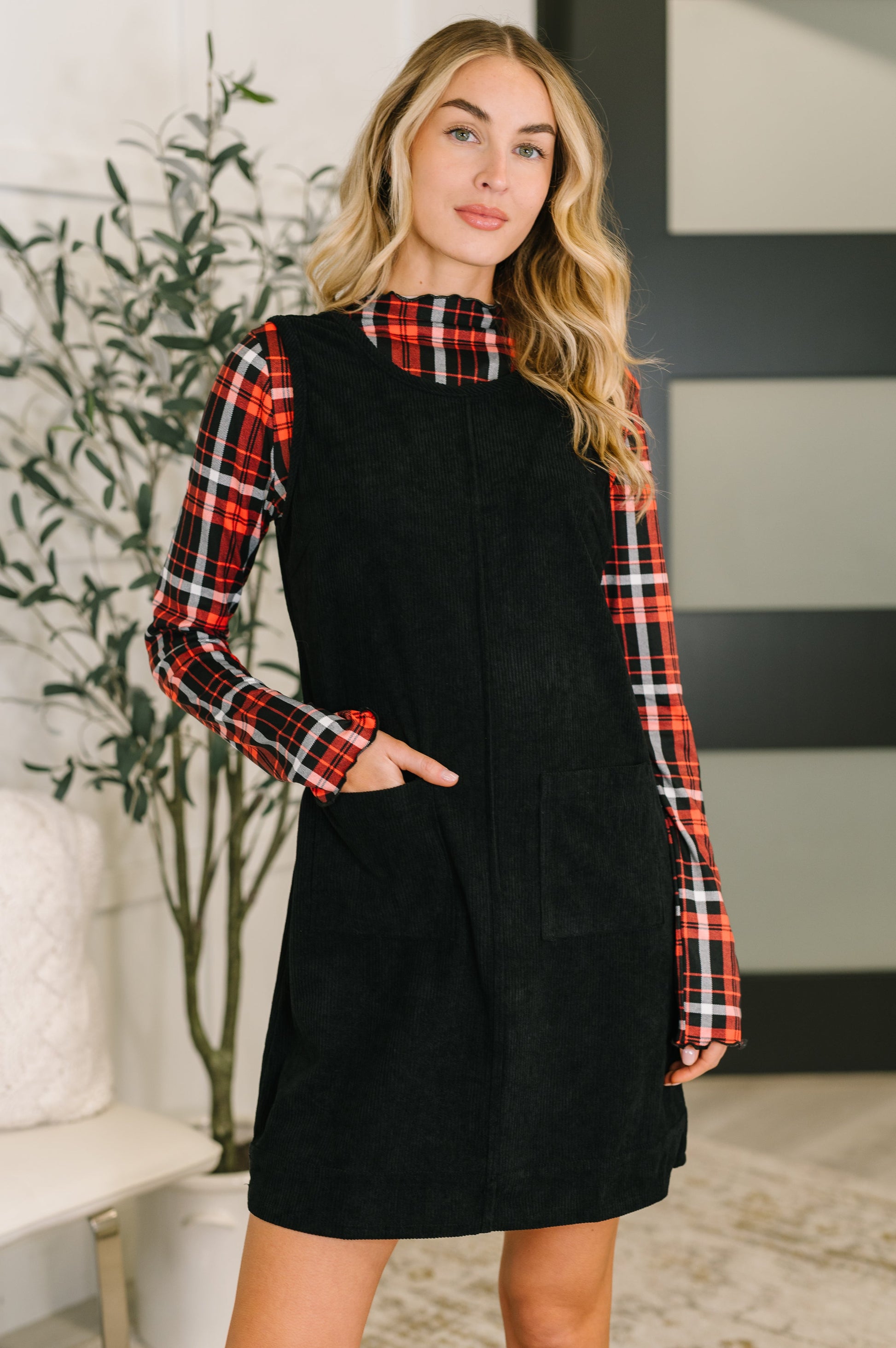 Model wearing Flannery Corduroy Dress in black with patch pockets and center seams.