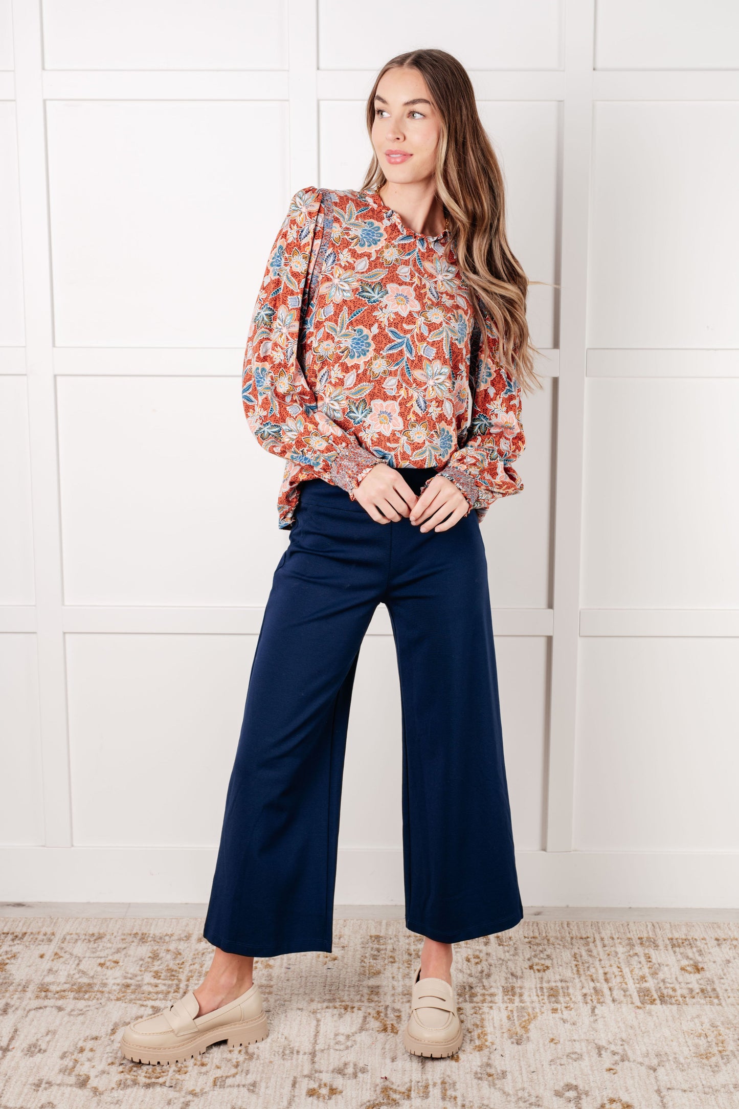 Full body view of model wearing Blair Floral Blouse styled with wide leg pants for a playful fall look