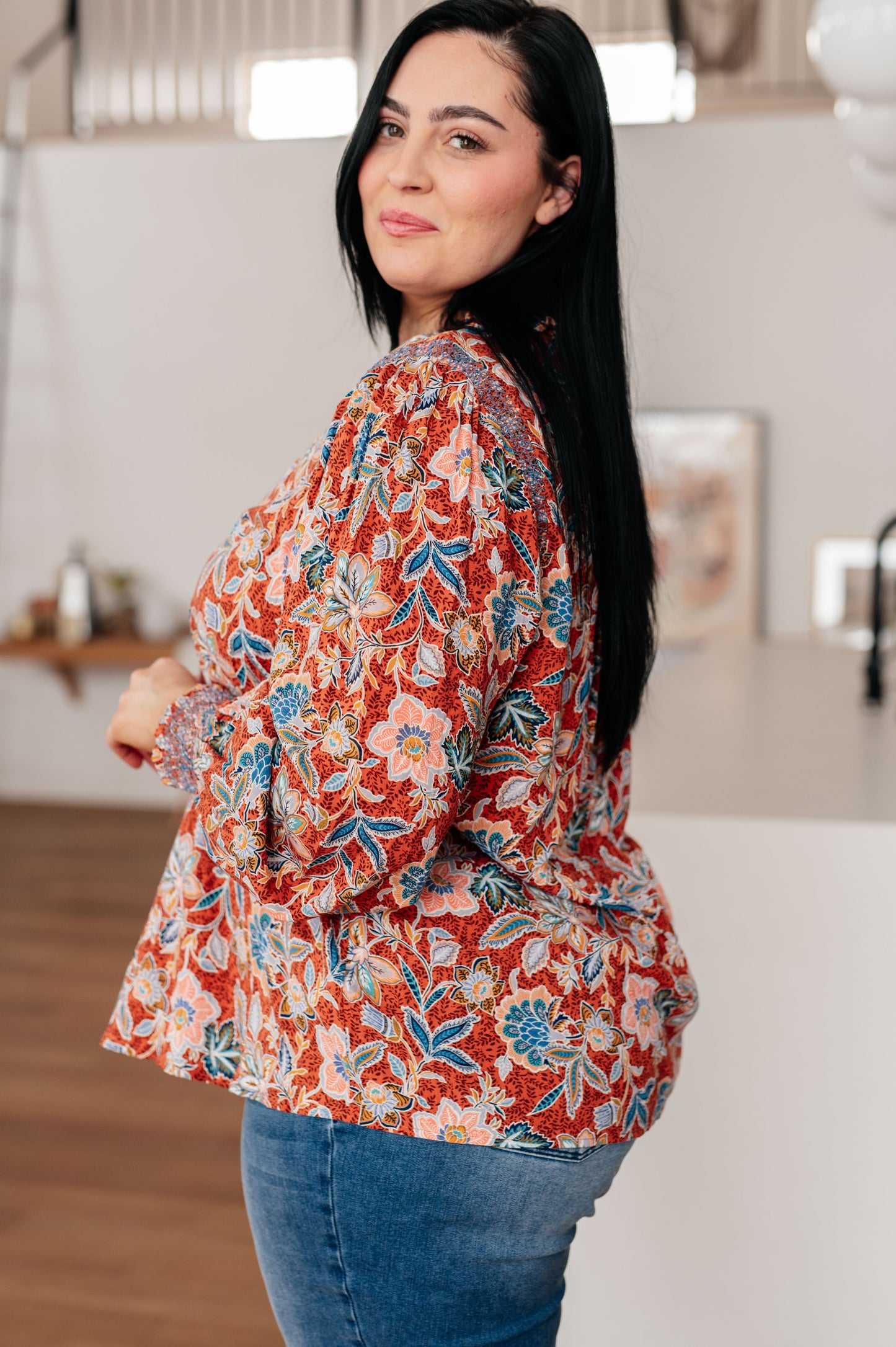 Side view of Blair Floral Blouse showing ruffled neckline, smocked sleeve cuffs, and flowy fit.