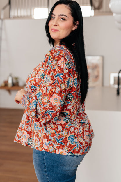 Side view of Blair Floral Blouse showing ruffled neckline, smocked sleeve cuffs, and flowy fit.