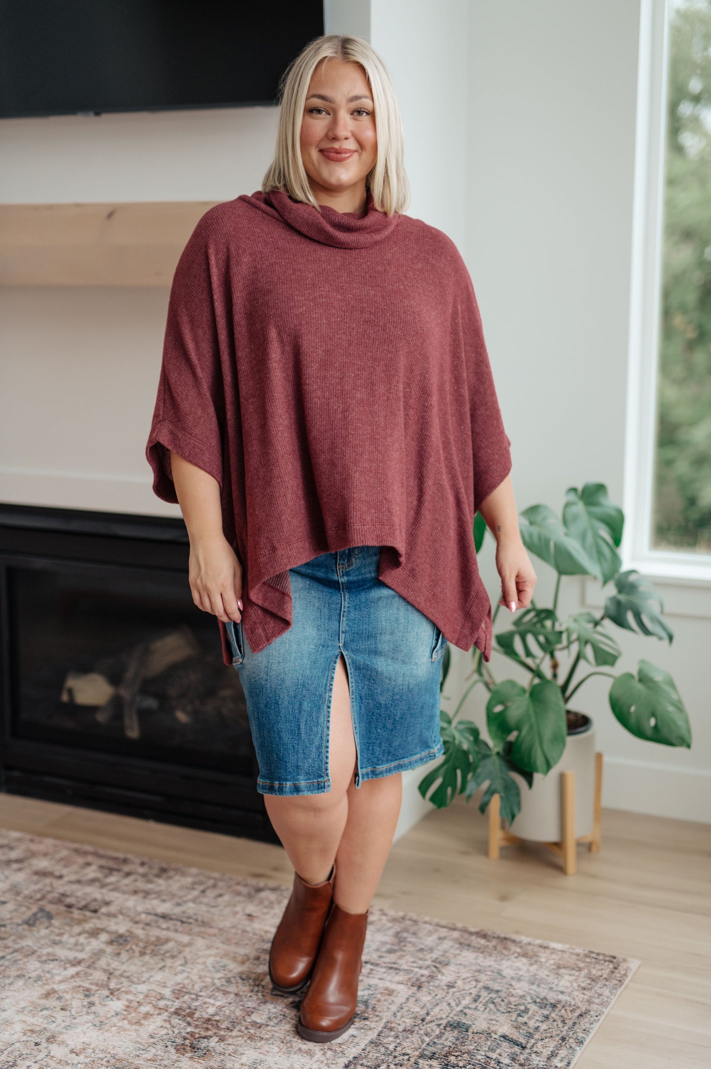 Women's dark mauve poncho made from brushed ribbed hacci knit fabric, featuring a cowl neckline, poncho silhouette, side slit, and a relaxed fit.