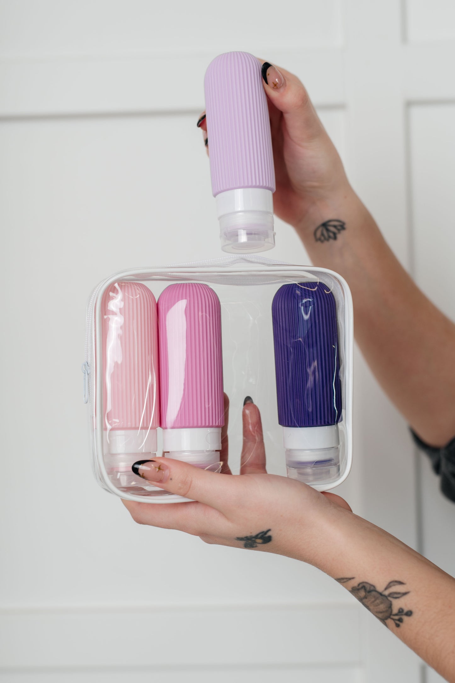 Lavender and pink silicone toiletry travel bottles, leak-proof, TSA-approved, with wide mouths and no-drip valves for easy use.