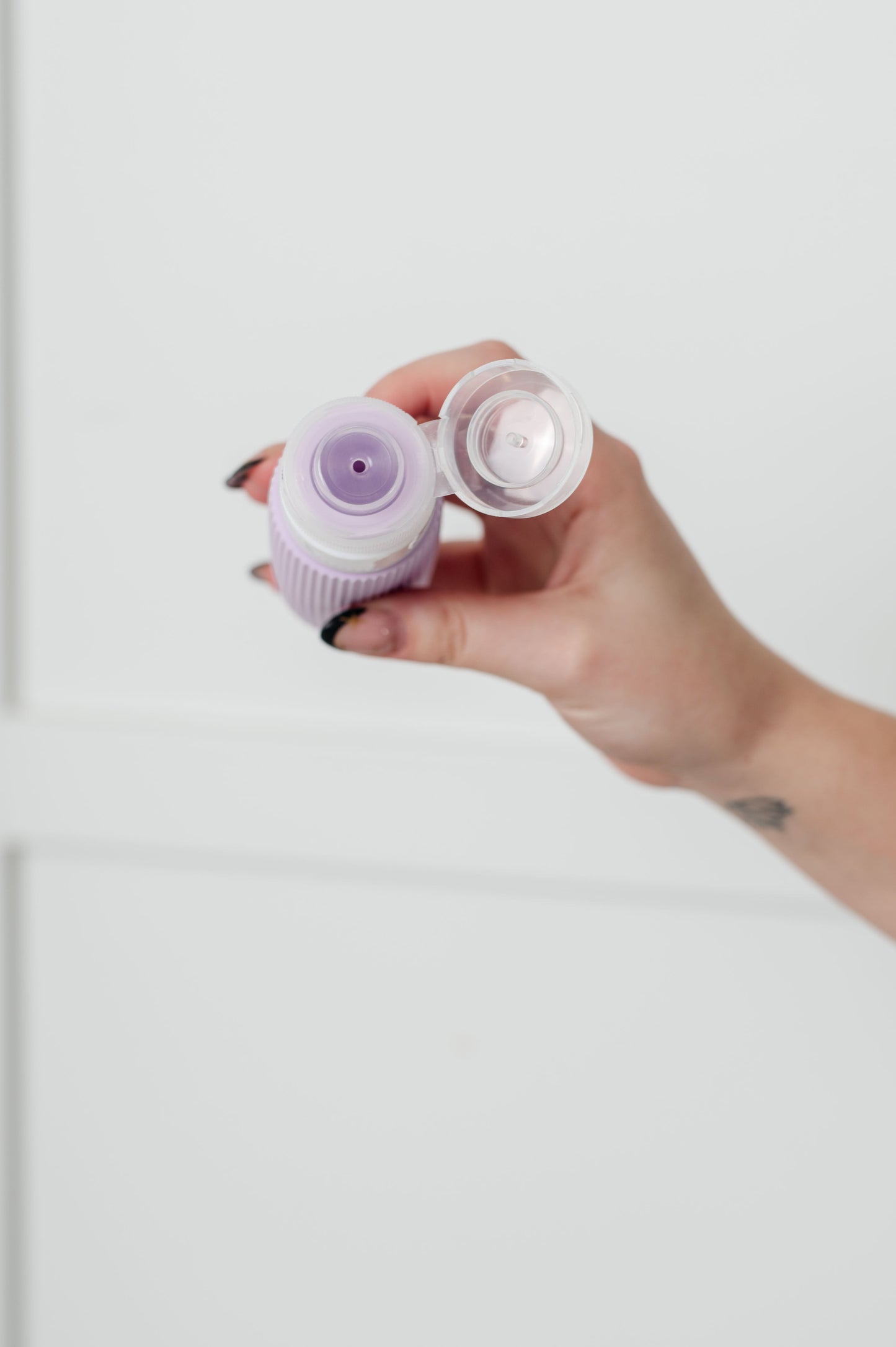 Lavender and pink silicone toiletry travel bottles, leak-proof, TSA-approved, with wide mouths and no-drip valves for easy use.