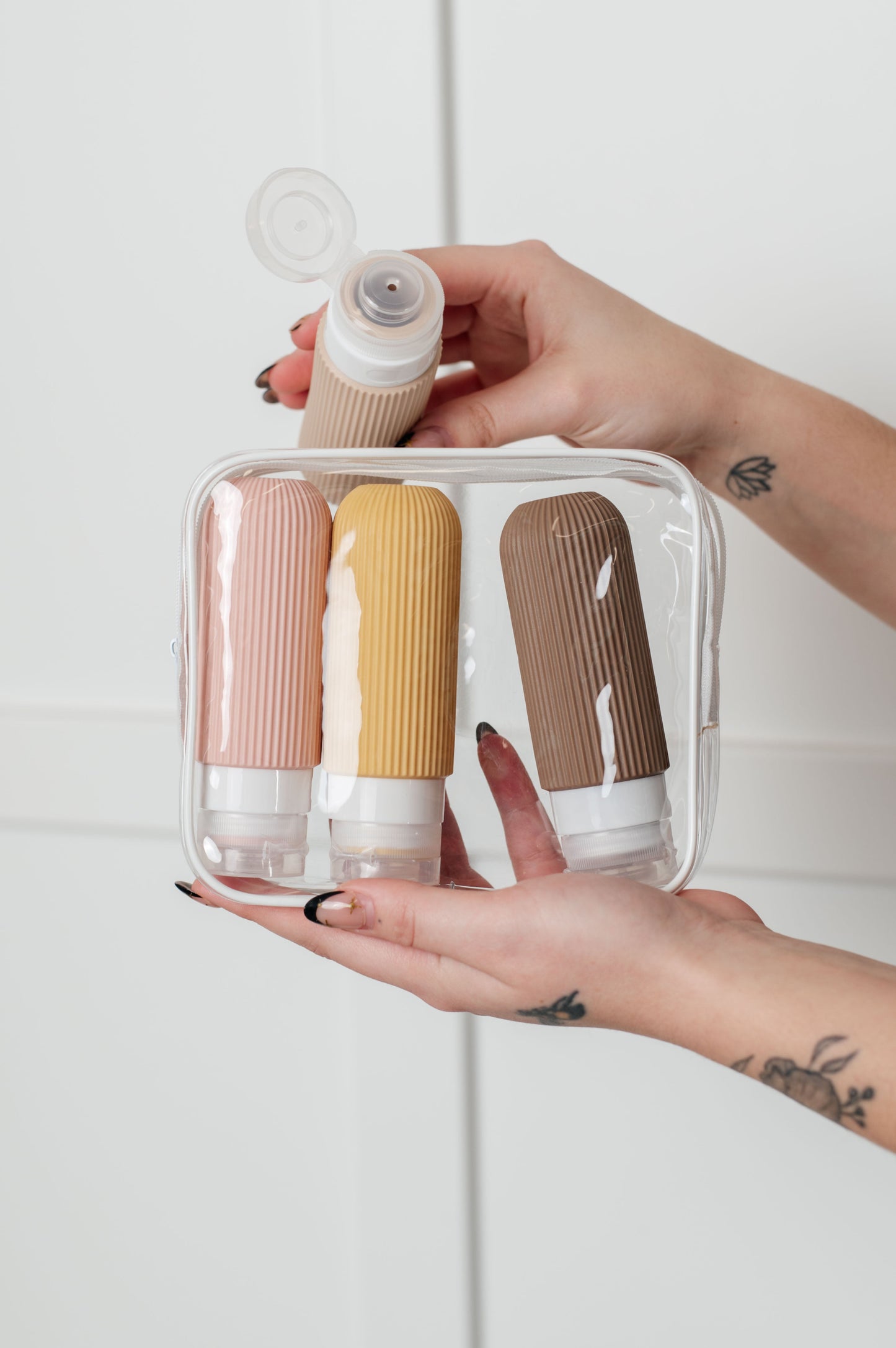 Neutral silicone toiletry travel bottles, leak-proof, TSA-approved, with wide mouths and no-drip valves for easy use.