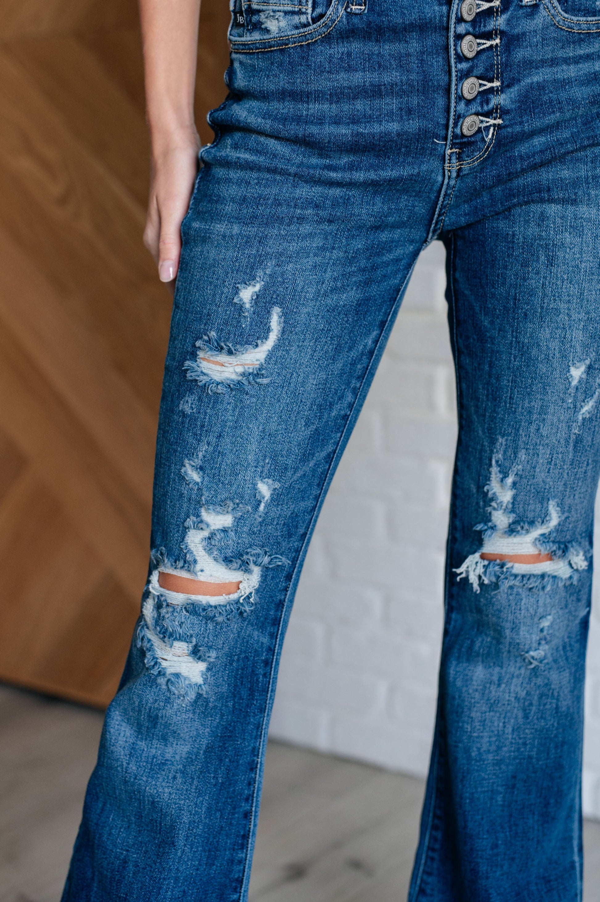 Distressed Button Fly Flare Jeans by Judy Blue, featuring mid-rise, button fly closure, and slight distressing on pockets and legs. Stretchy denim with a slim fit through thighs flares out at the ankle for a stylish silhouette. 