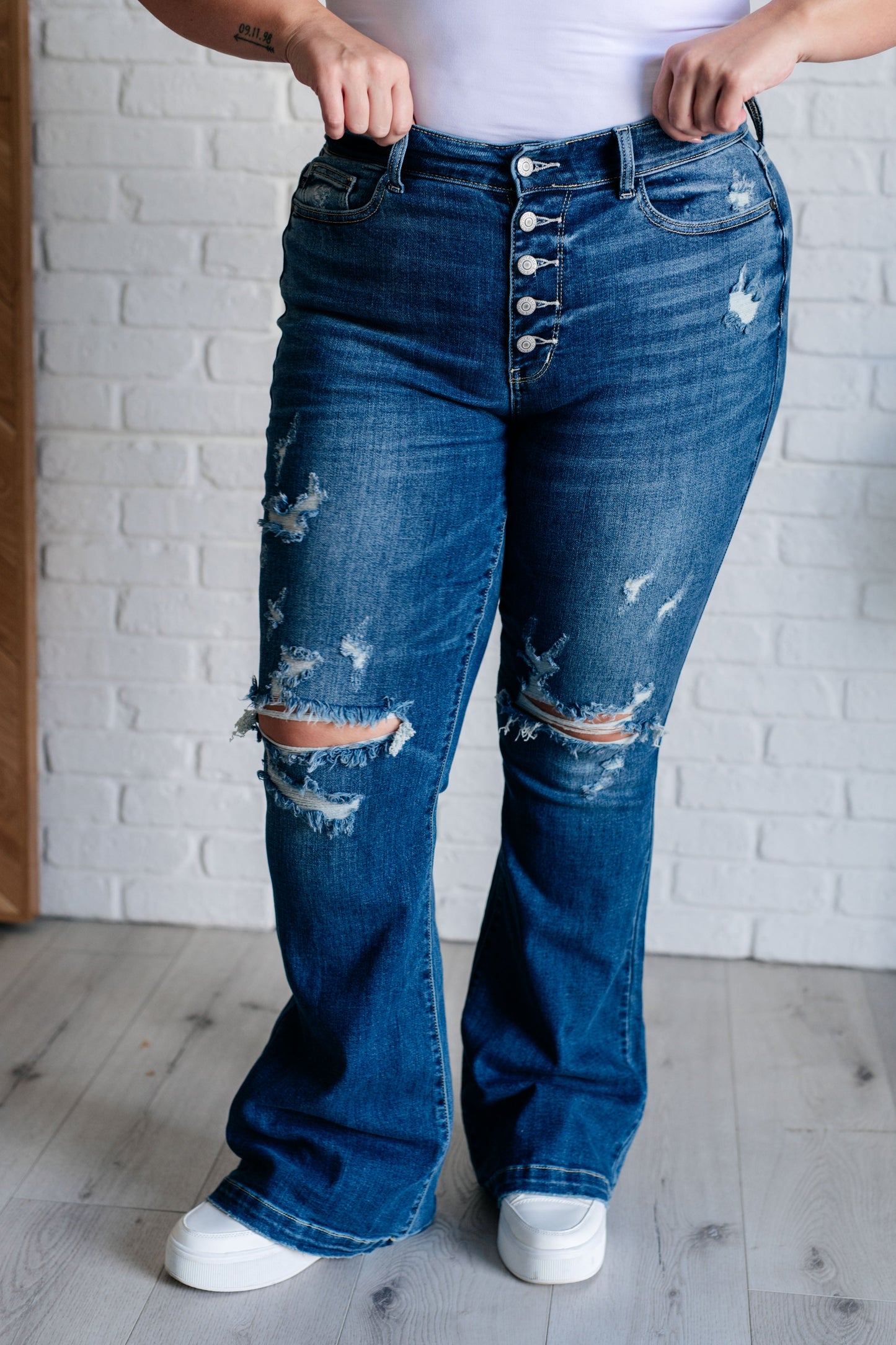 Distressed Button Fly Flare Jeans by Judy Blue, featuring mid-rise, button fly closure, and slight distressing on pockets and legs. Stretchy denim with a slim fit through thighs flares out at the ankle for a stylish silhouette. 