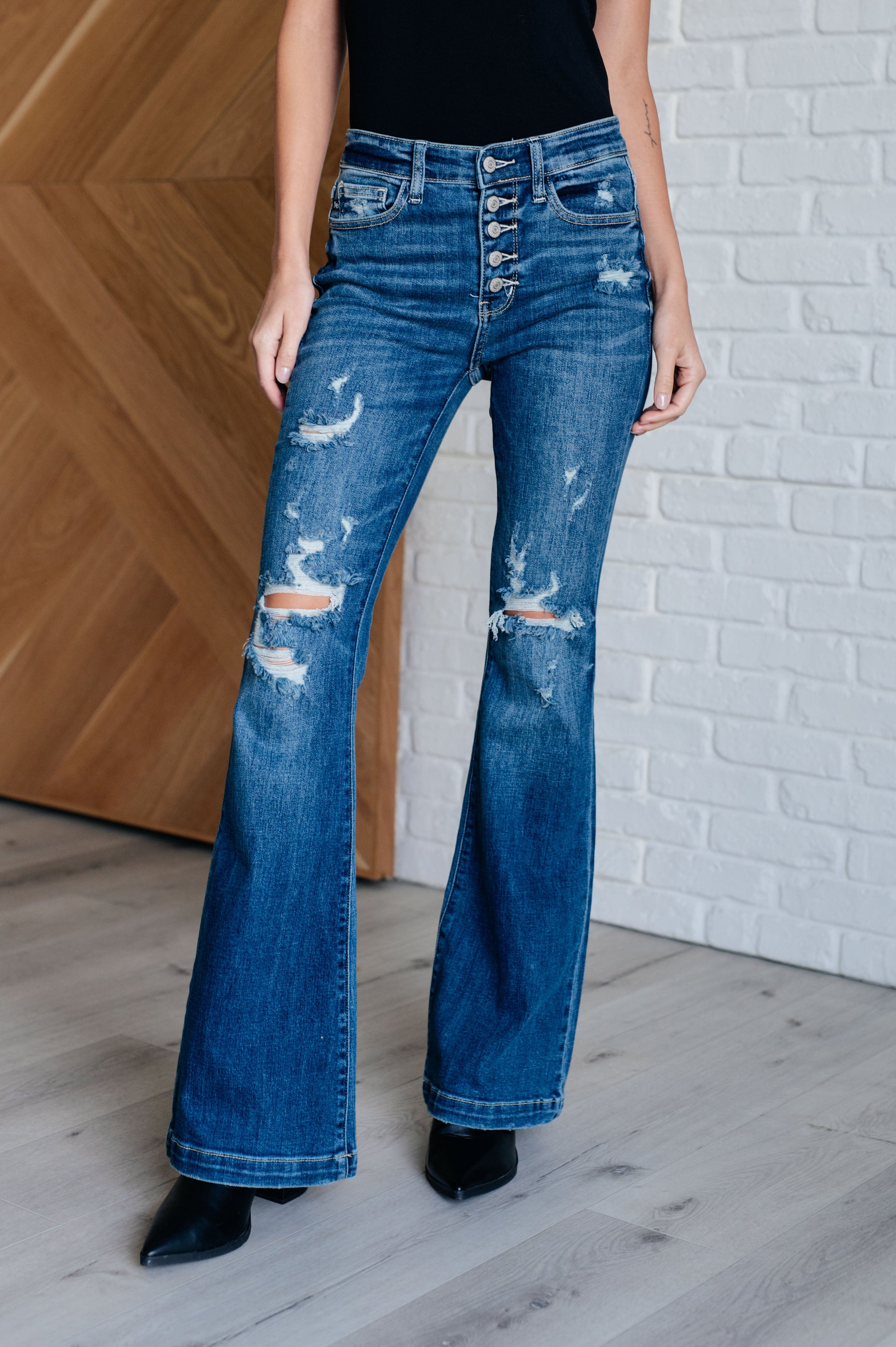 Distressed Button Fly Flare Jeans by Judy Blue, featuring mid-rise, button fly closure, and slight distressing on pockets and legs. Stretchy denim with a slim fit through thighs flares out at the ankle for a stylish silhouette. 