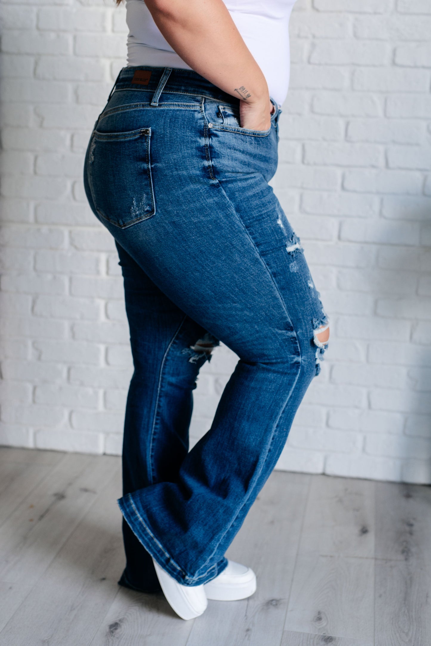 Distressed Button Fly Flare Jeans by Judy Blue, featuring mid-rise, button fly closure, and slight distressing on pockets and legs. Stretchy denim with a slim fit through thighs flares out at the ankle for a stylish silhouette. 