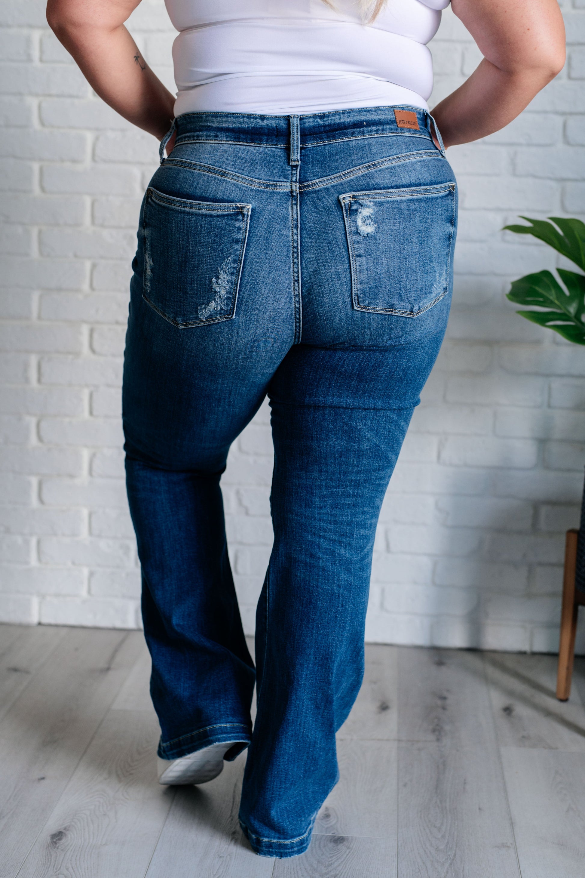 Distressed Button Fly Flare Jeans by Judy Blue, featuring mid-rise, button fly closure, and slight distressing on pockets and legs. Stretchy denim with a slim fit through thighs flares out at the ankle for a stylish silhouette. 