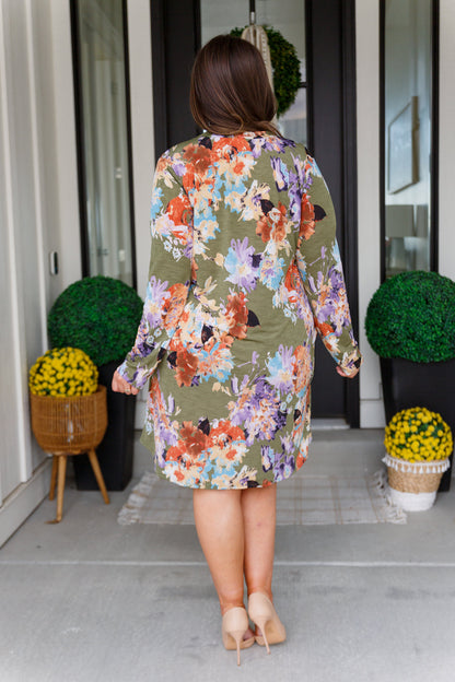 Plus-size model back view of Paloma olive floral dress with relaxed shift silhouette.