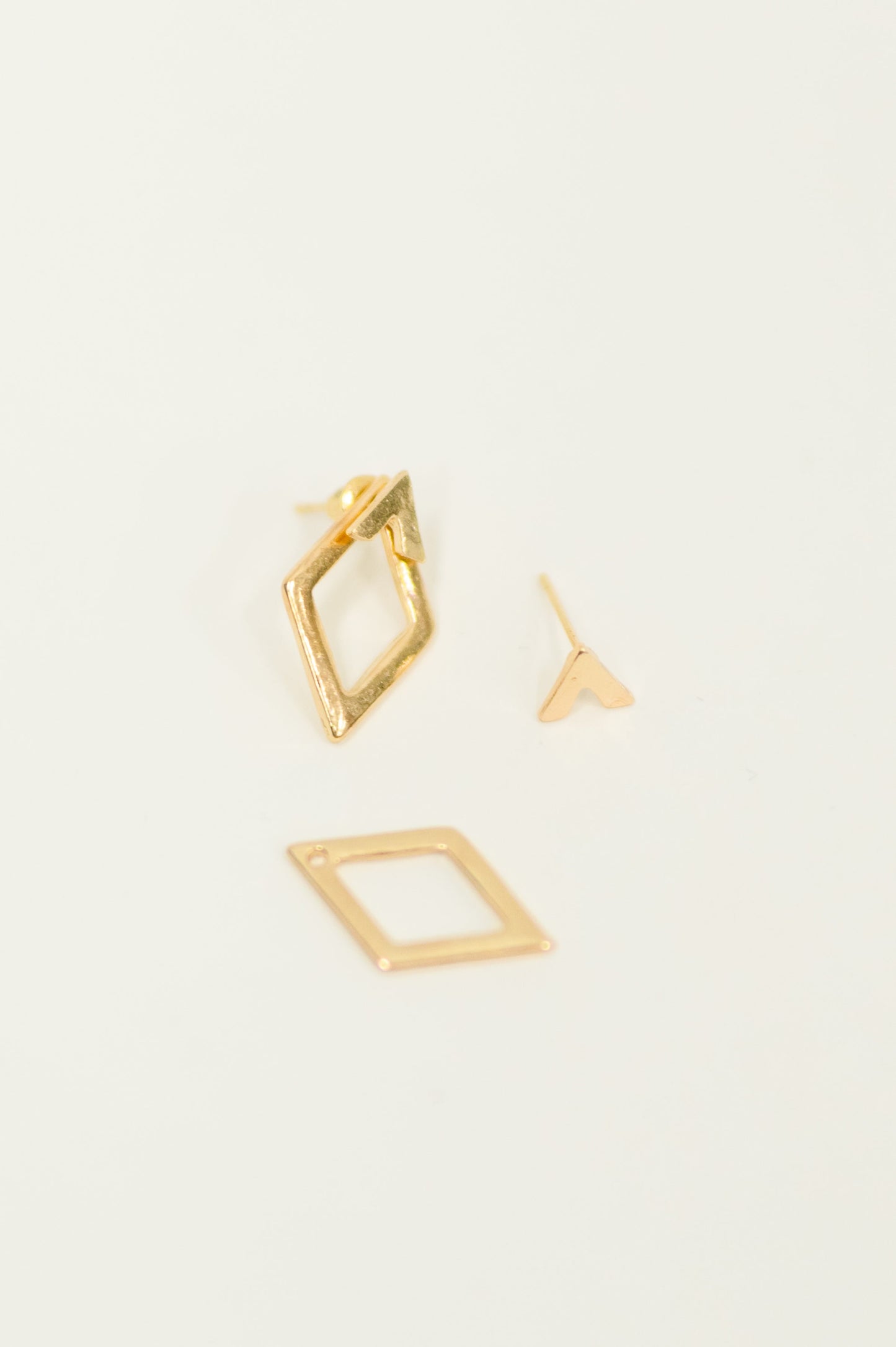 Flat lay of Geometric Rhombus Stud Earrings showing two-piece stud design.