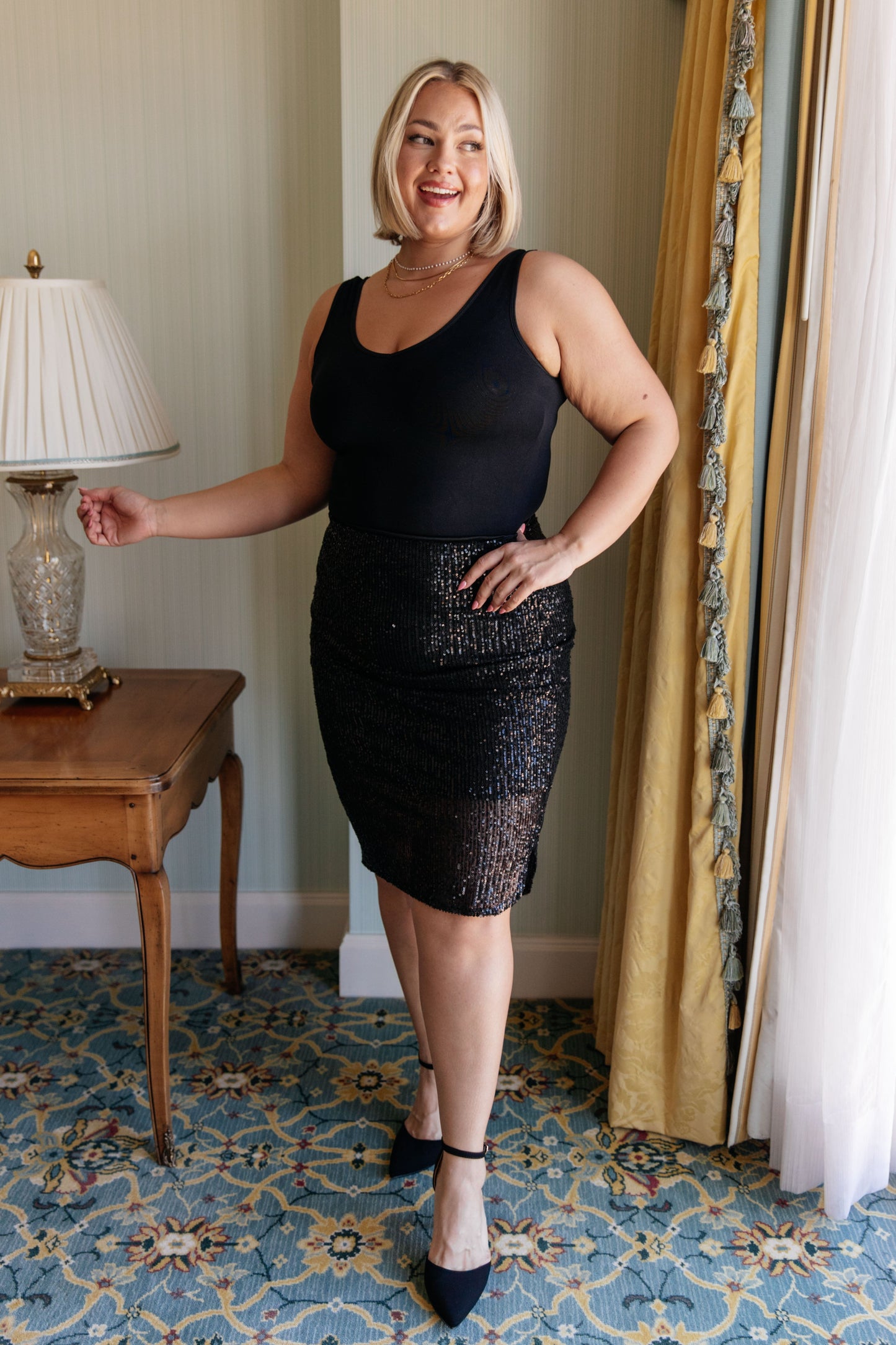 Sequin Skirt in black, featuring a sequin mesh fabric, tulip hem, cased elastic waistband, and fully lined for a flattering fit and elegant look.