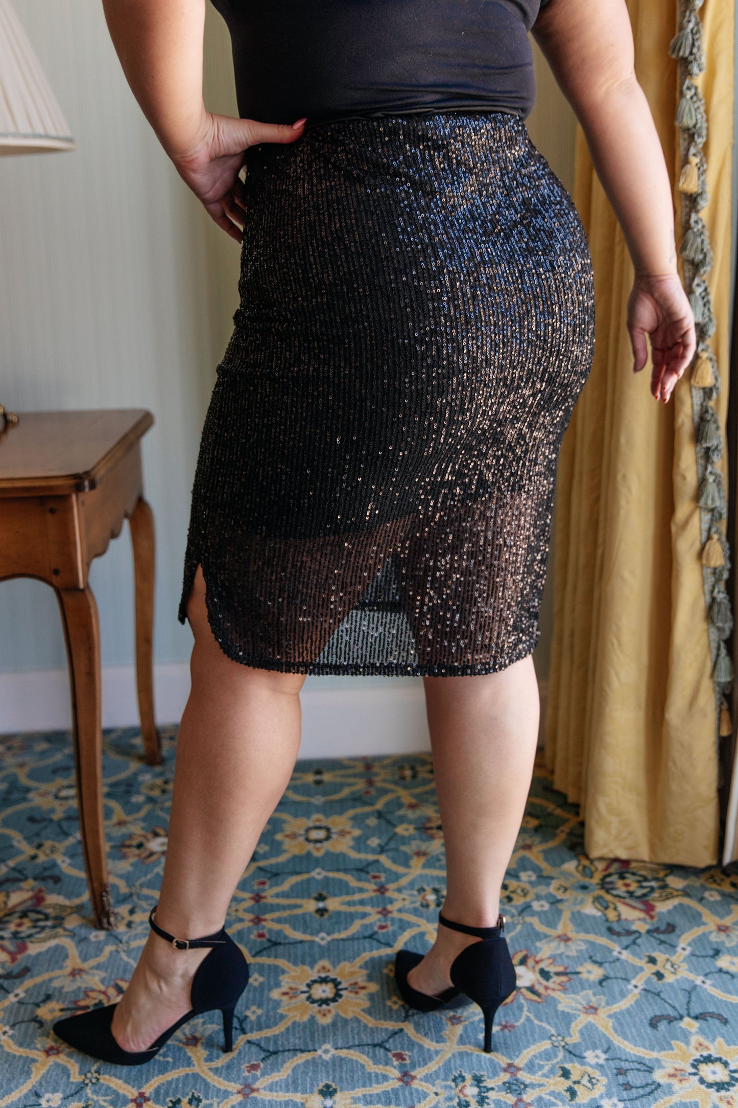 Sequin Skirt in black, featuring a sequin mesh fabric, tulip hem, cased elastic waistband, and fully lined for a flattering fit and elegant look.