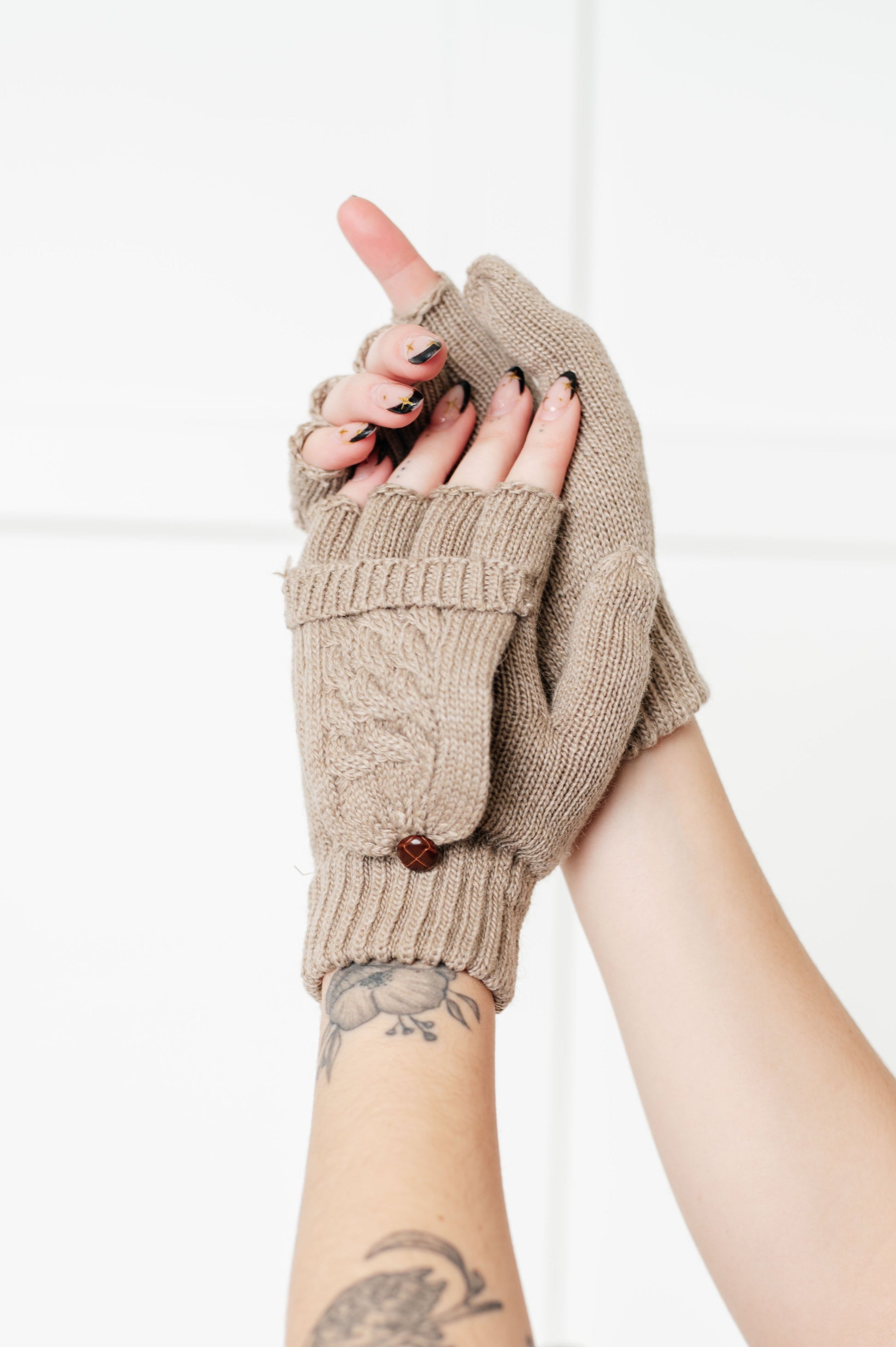 Women's flip-top gloves in beige, featuring a cable knit design, split finger mittens, and button closure.