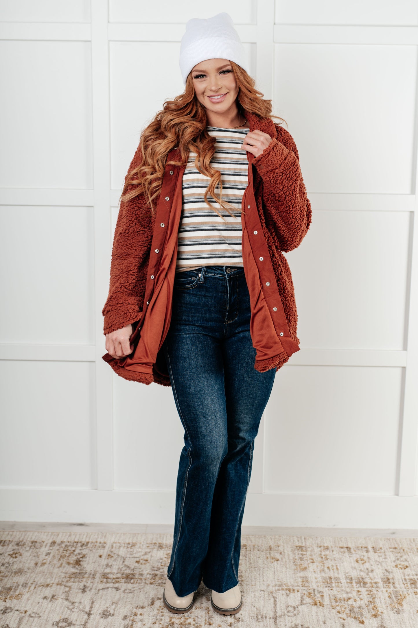 Gresia Sherpa Jacket in cinnamon, featuring soft sherpa material, collared neckline, scooped hemline, snap button closure, zipper pocket, and side pockets, fully lined for comfort.