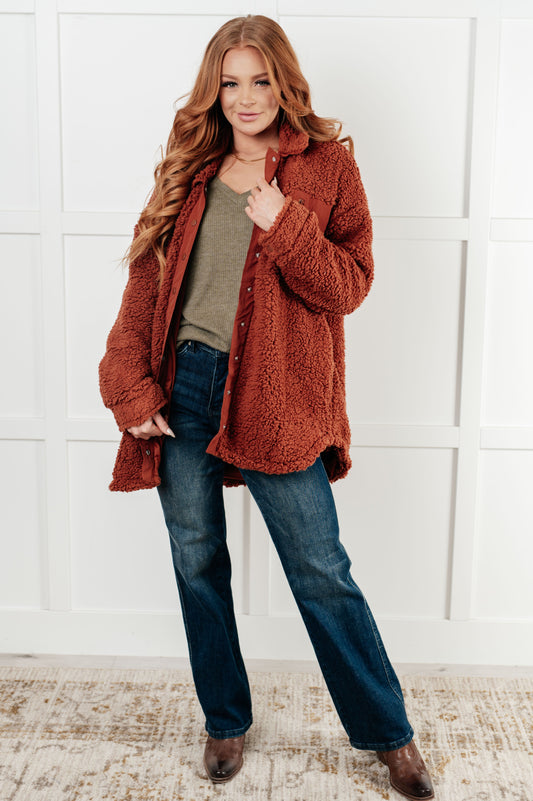 Gresia Sherpa Jacket in cinnamon, featuring soft sherpa material, collared neckline, scooped hemline, snap button closure, zipper pocket, and side pockets, fully lined for comfort.