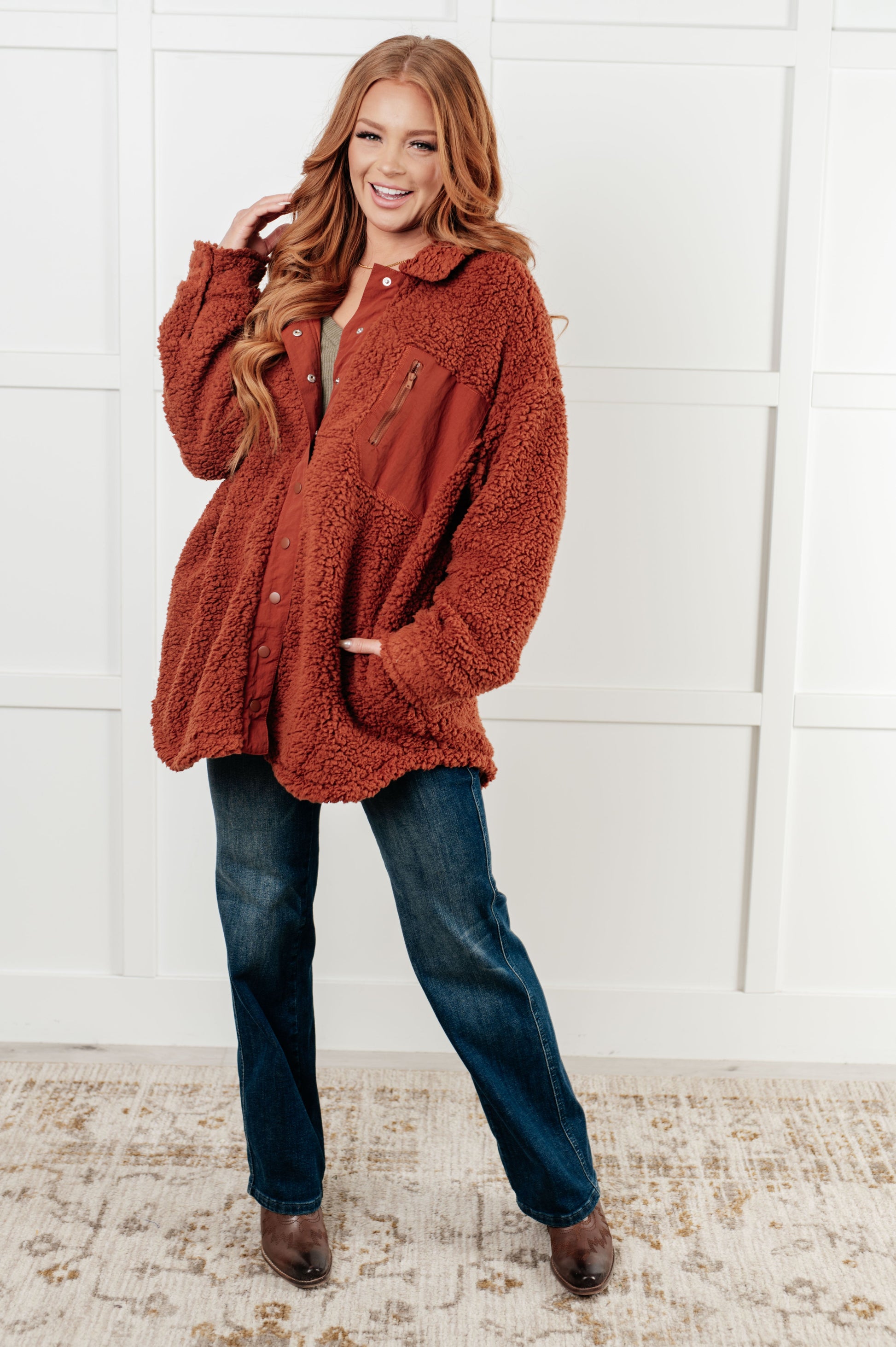 Gresia Sherpa Jacket in cinnamon, featuring soft sherpa material, collared neckline, scooped hemline, snap button closure, zipper pocket, and side pockets, fully lined for comfort.