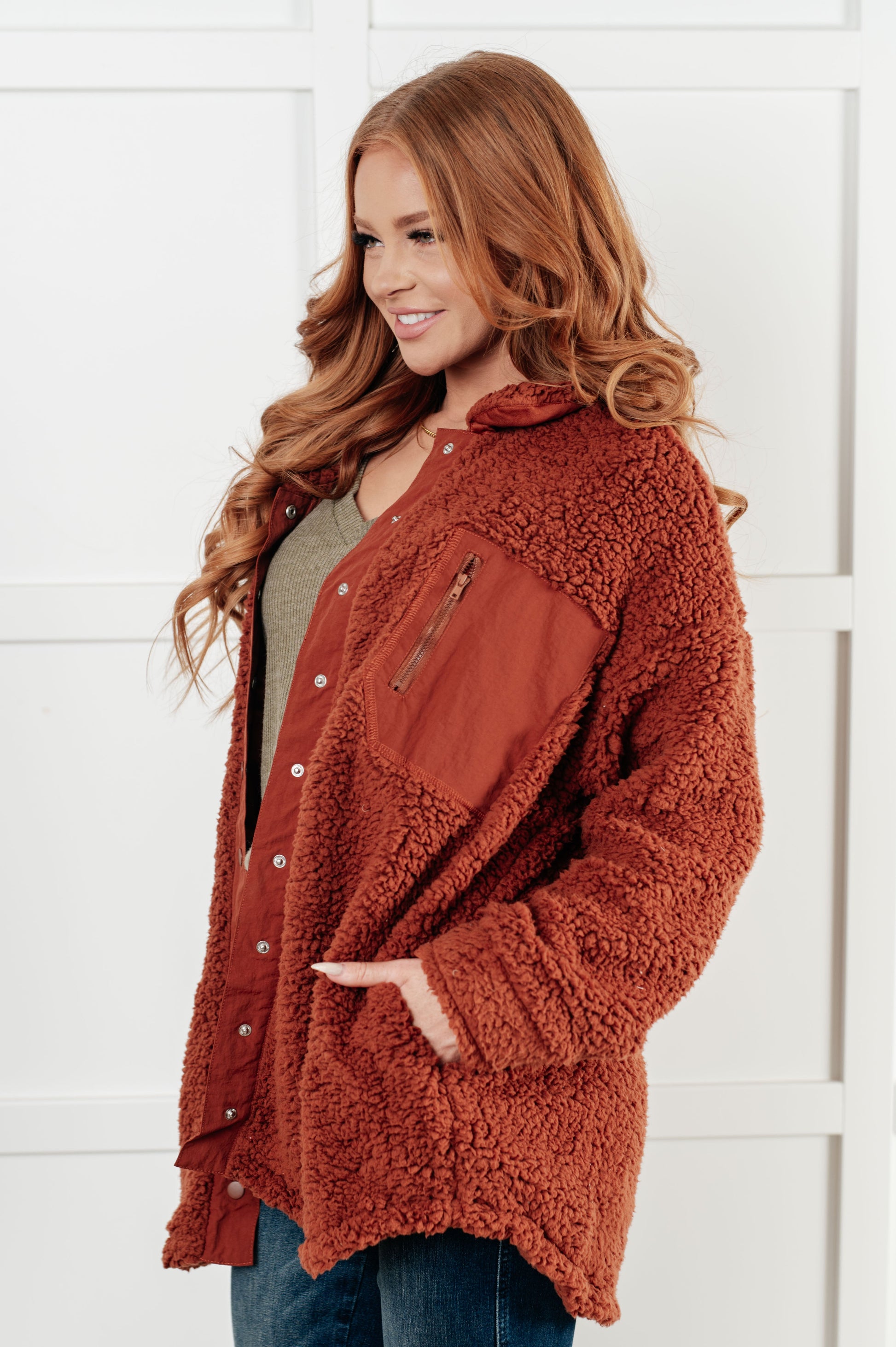 Gresia Sherpa Jacket in cinnamon, featuring soft sherpa material, collared neckline, scooped hemline, snap button closure, zipper pocket, and side pockets, fully lined for comfort.