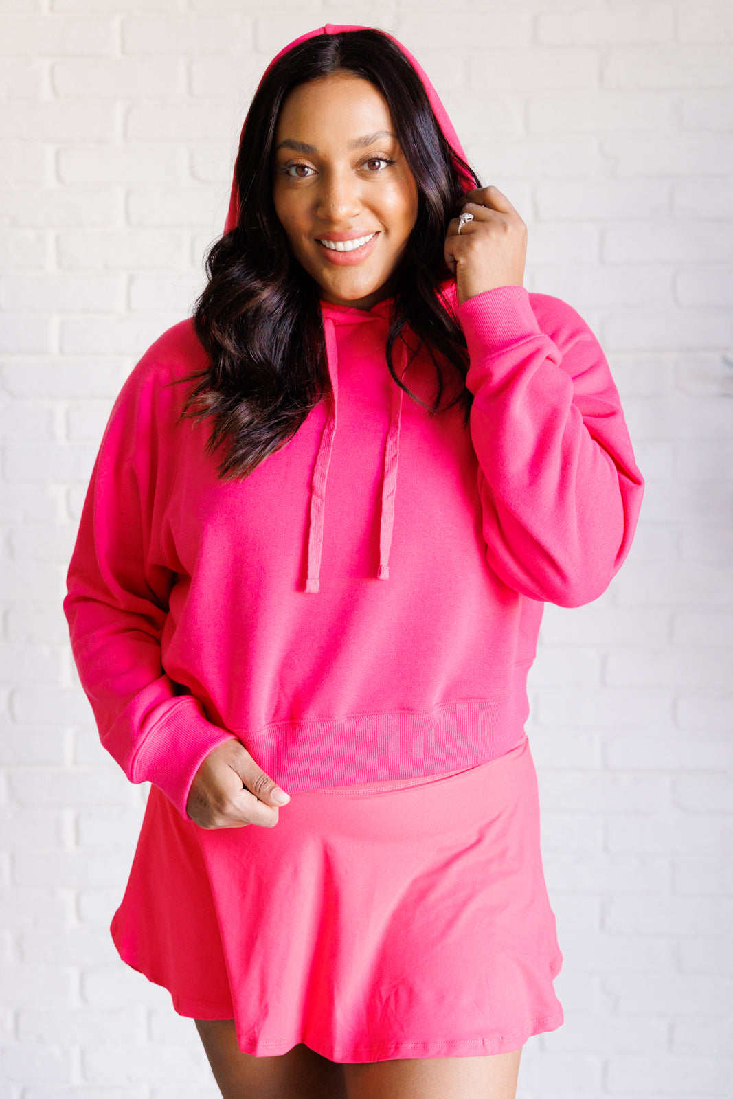 Flamingo pink French terry cropped hoodie with a hood and functional drawstring, dolman long sleeves, and banded ribbed cuffs and hemline.