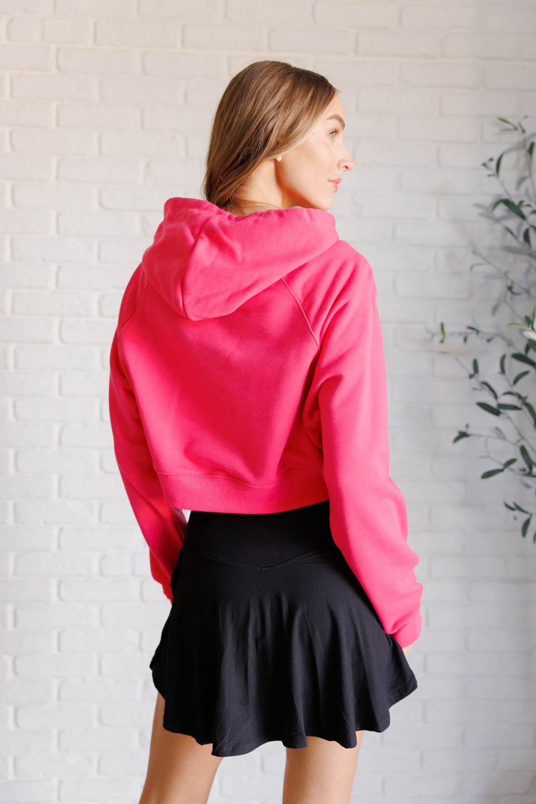 Flamingo pink French terry cropped hoodie with a hood and functional drawstring, dolman long sleeves, and banded ribbed cuffs and hemline.