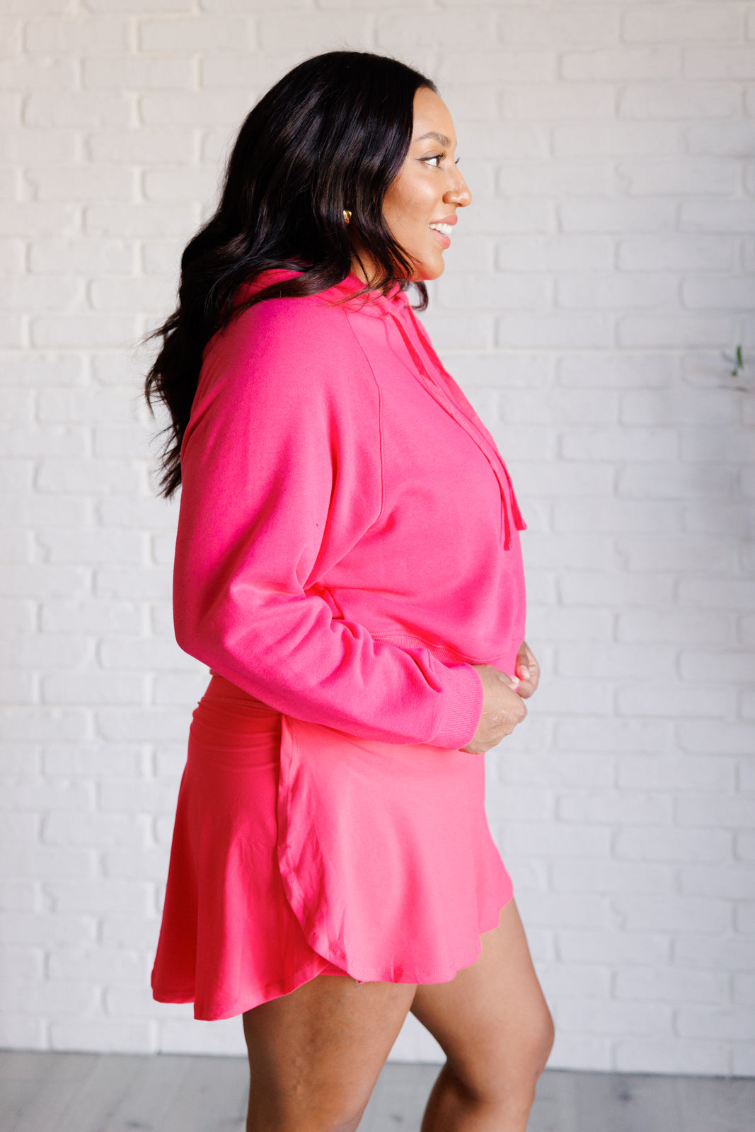 Flamingo pink French terry cropped hoodie with a hood and functional drawstring, dolman long sleeves, and banded ribbed cuffs and hemline.