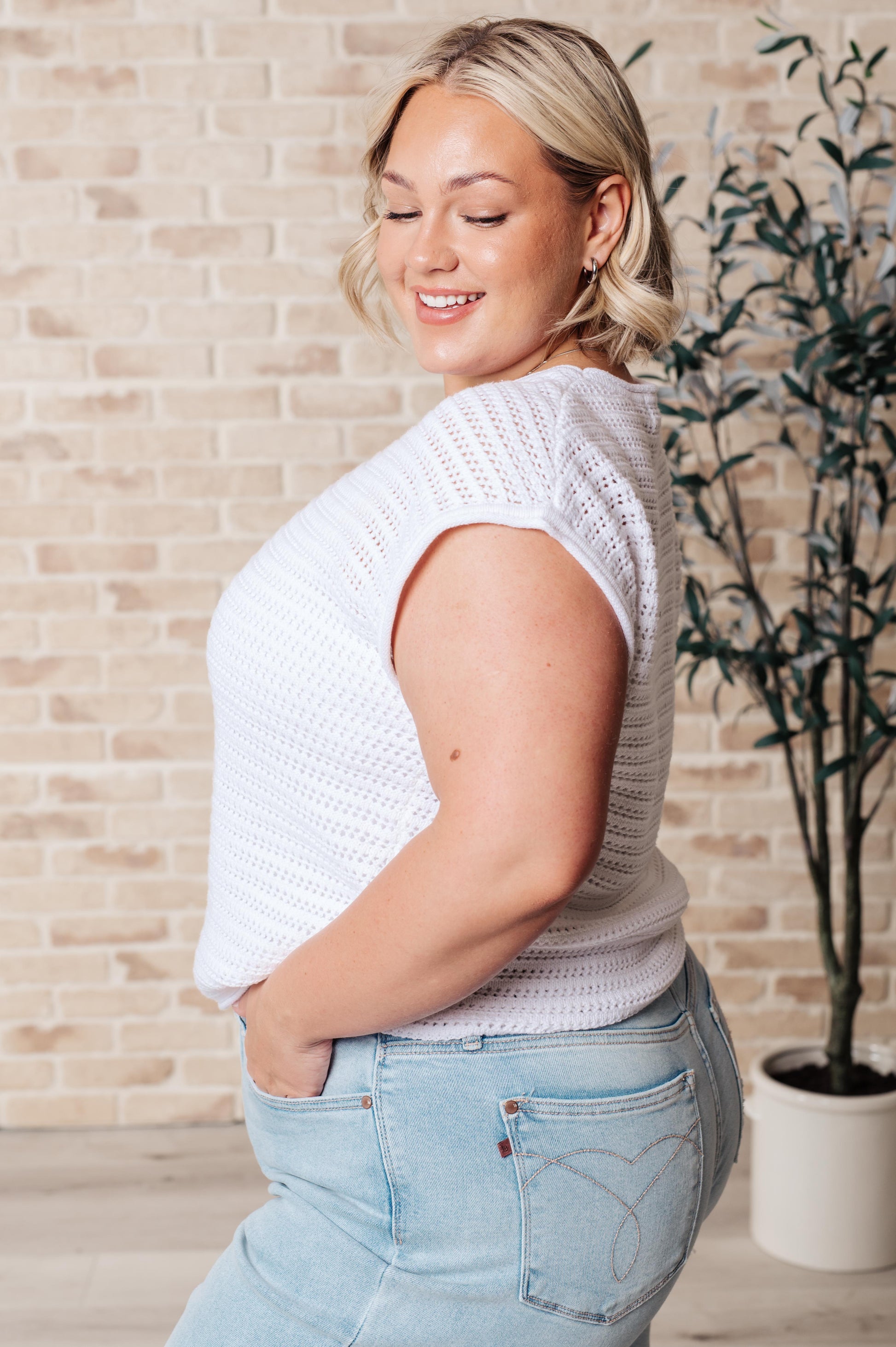 Side view of plus size Callie Open Knit Cap Sleeve Sweater in white, featuring relaxed dolman sleeves and textured ribbed cuffs.