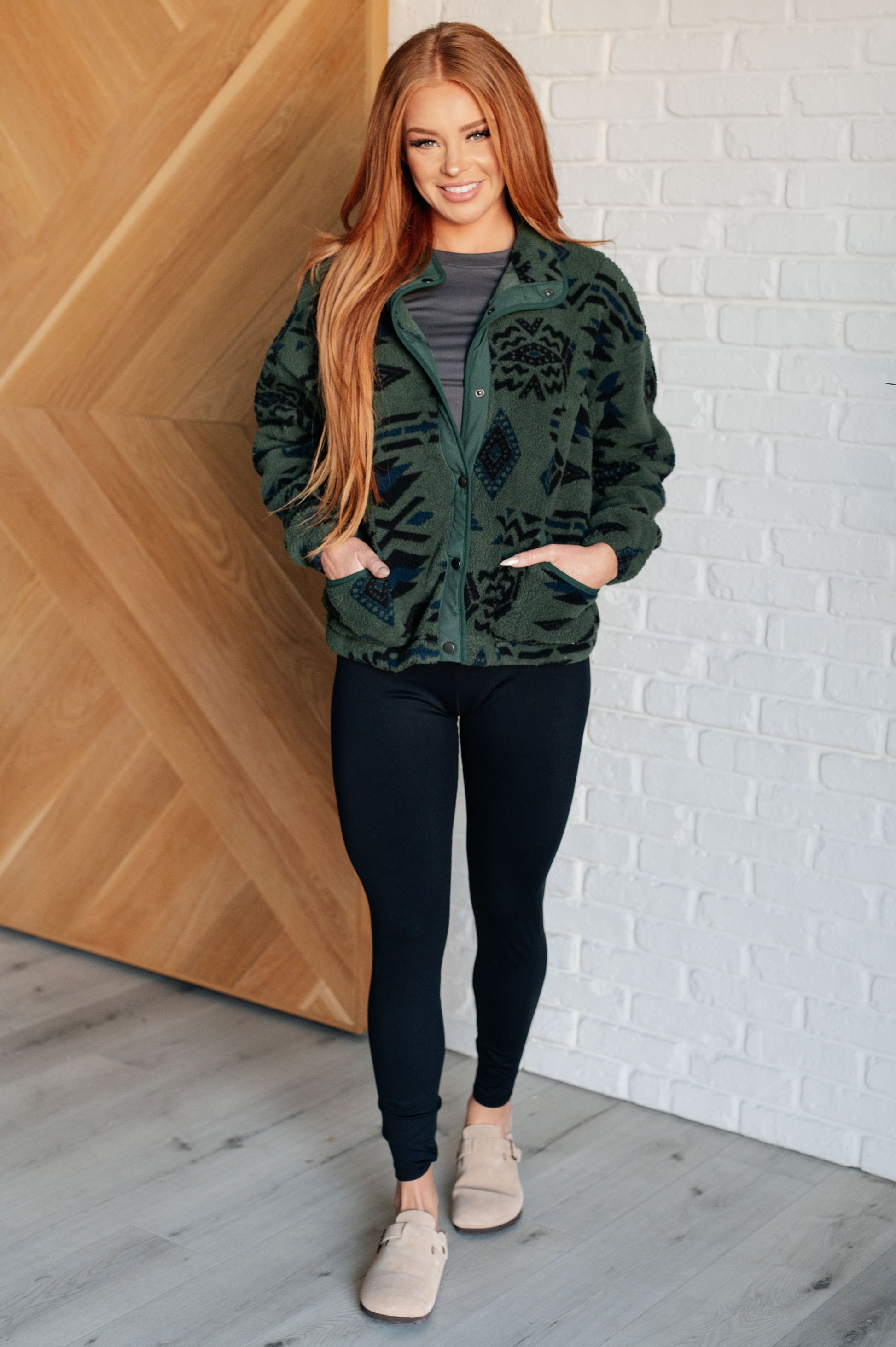 Women's green jacket made of soft polar fleece with a geometric pattern, featuring a snap front, mock neckline, front pockets, contoured seams, and dropped shoulders.