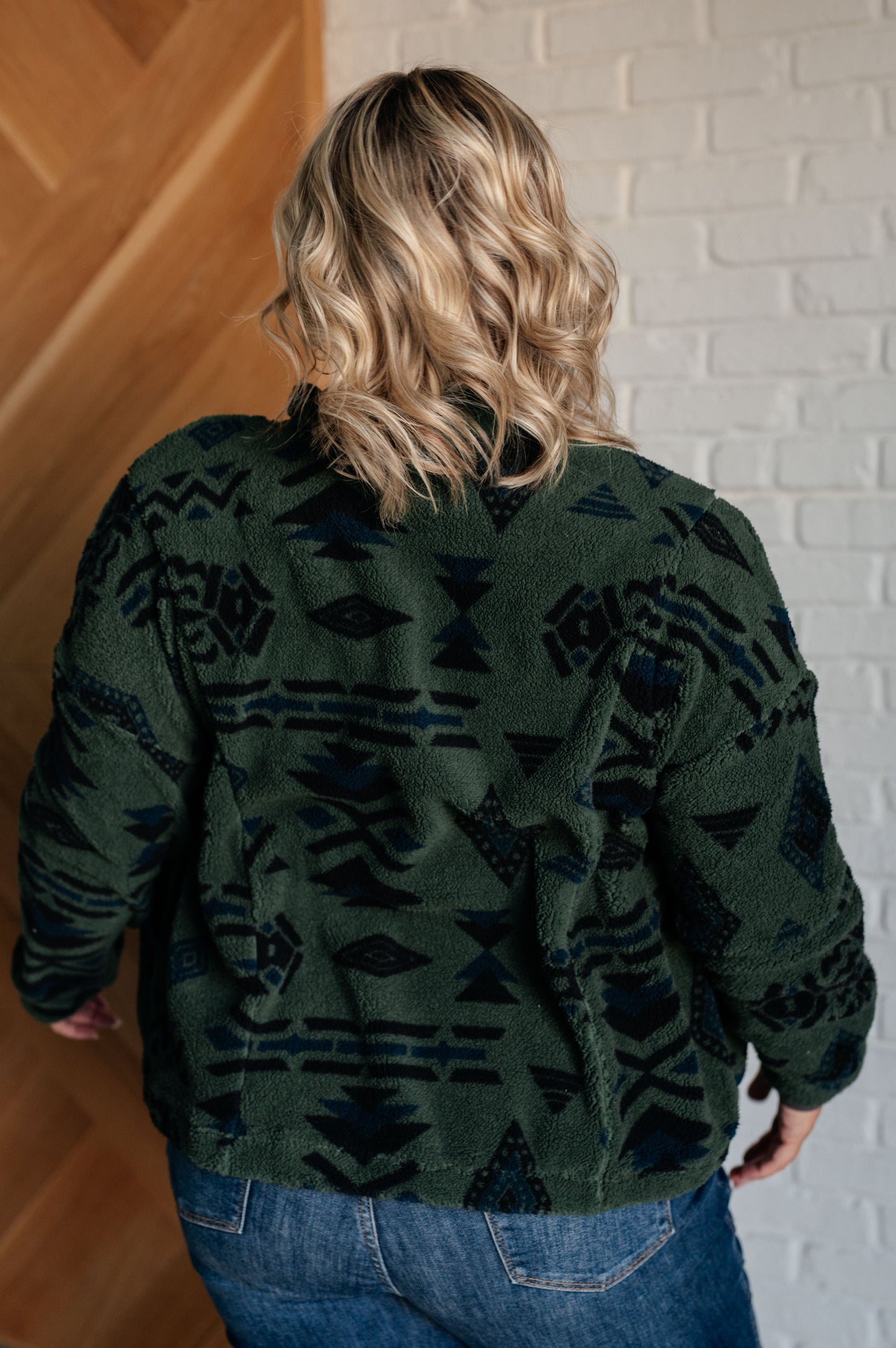 Women's green jacket made of soft polar fleece with a geometric pattern, featuring a snap front, mock neckline, front pockets, contoured seams, and dropped shoulders.