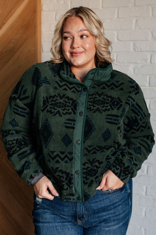 Women's green jacket made of soft polar fleece with a geometric pattern, featuring a snap front, mock neckline, front pockets, contoured seams, and dropped shoulders.