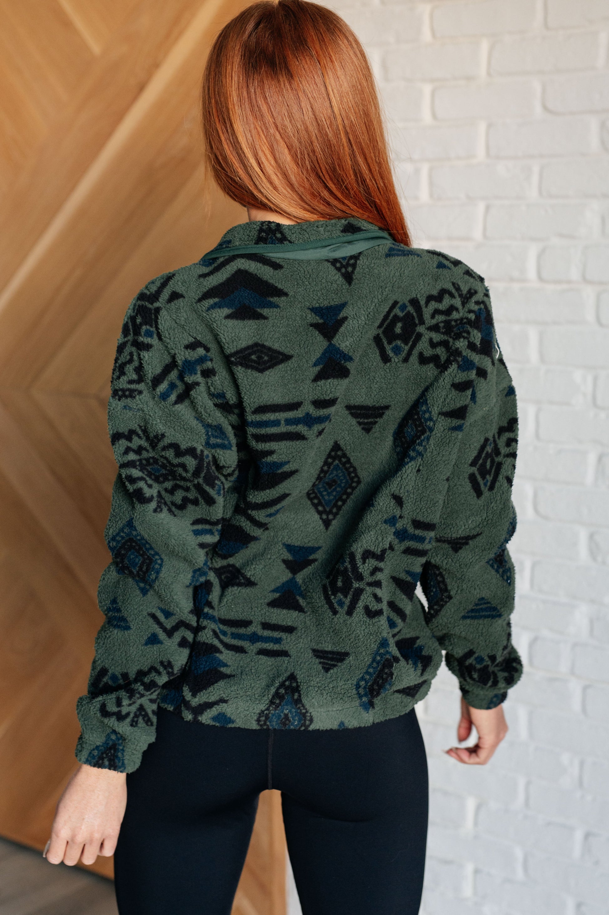 Women's green jacket made of soft polar fleece with a geometric pattern, featuring a snap front, mock neckline, front pockets, contoured seams, and dropped shoulders.