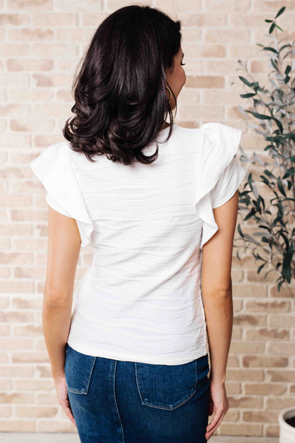 Back of Ila Blouse showing smooth knit fabric, round neckline, and clean silhouette.