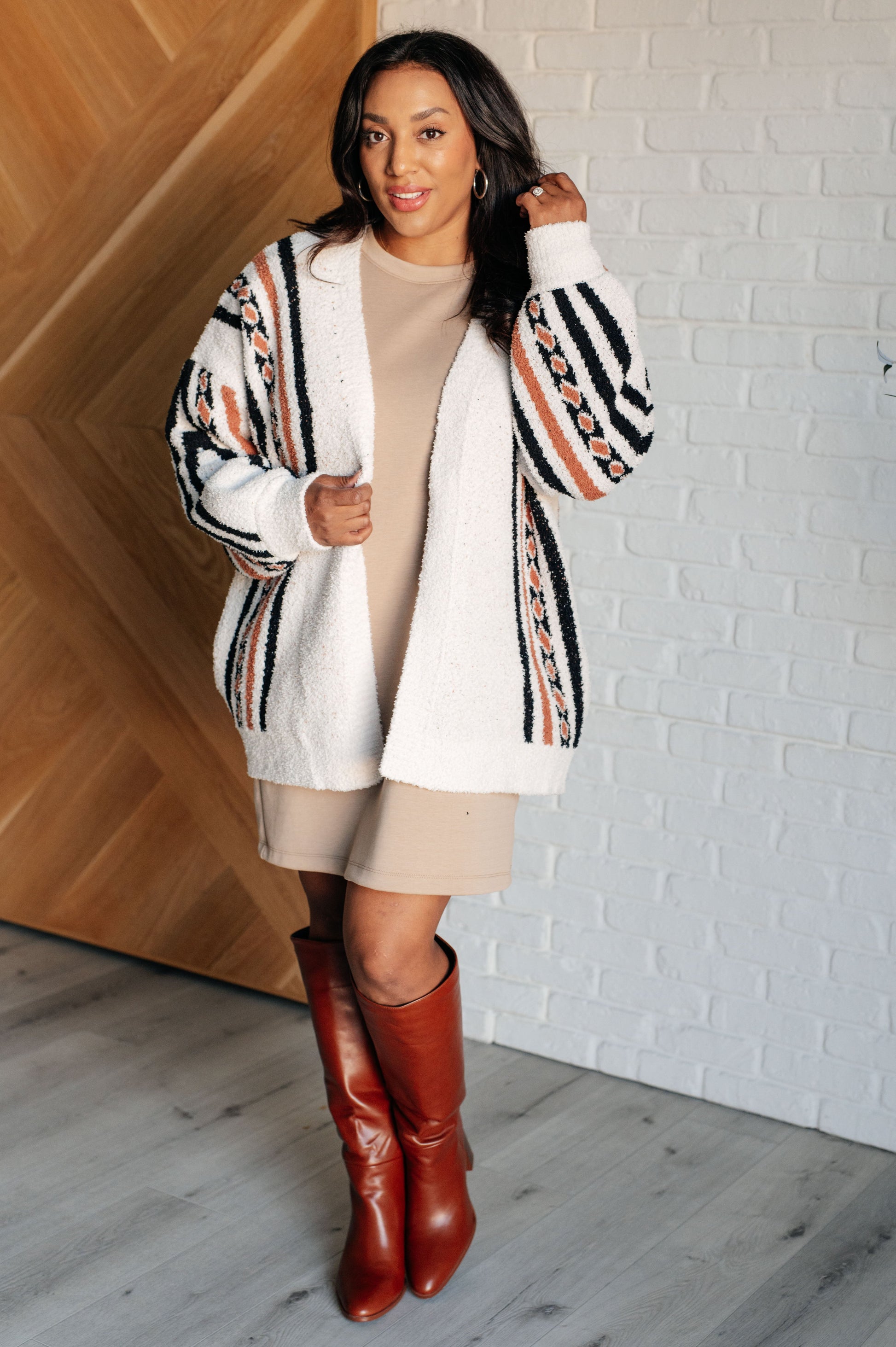 A mid-weight, off-white sweater knit cardigan featuring an Aztec print, an open front design, and long sleeves with a dropped shoulder style.