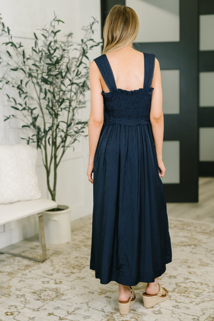 Back view of Holland Midi Dress in Navy featuring smocked bodice and structured skirt.