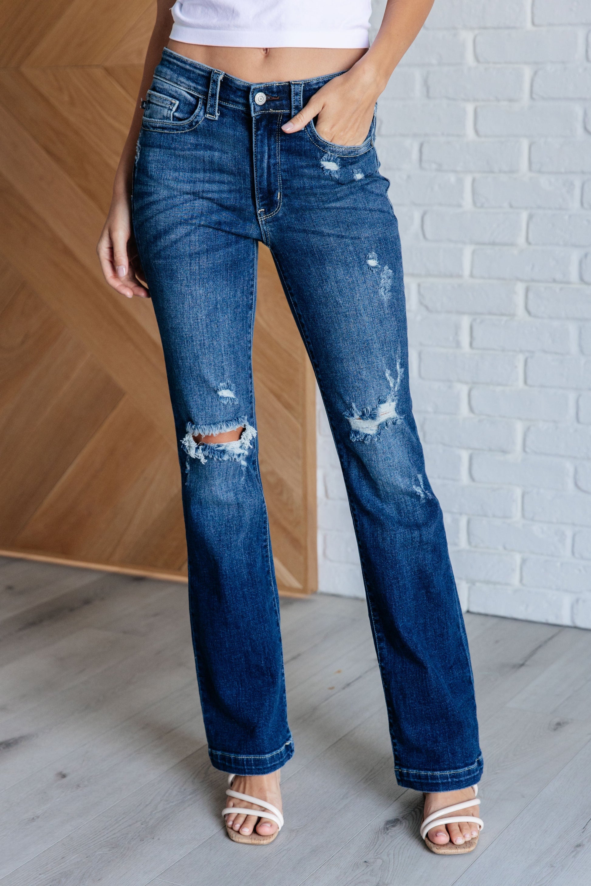 Judy Blue mid-rise distressed bootcut jeans in a dark wash, featuring a zip fly, 4-way stretch, and a stylish bootcut silhouette.